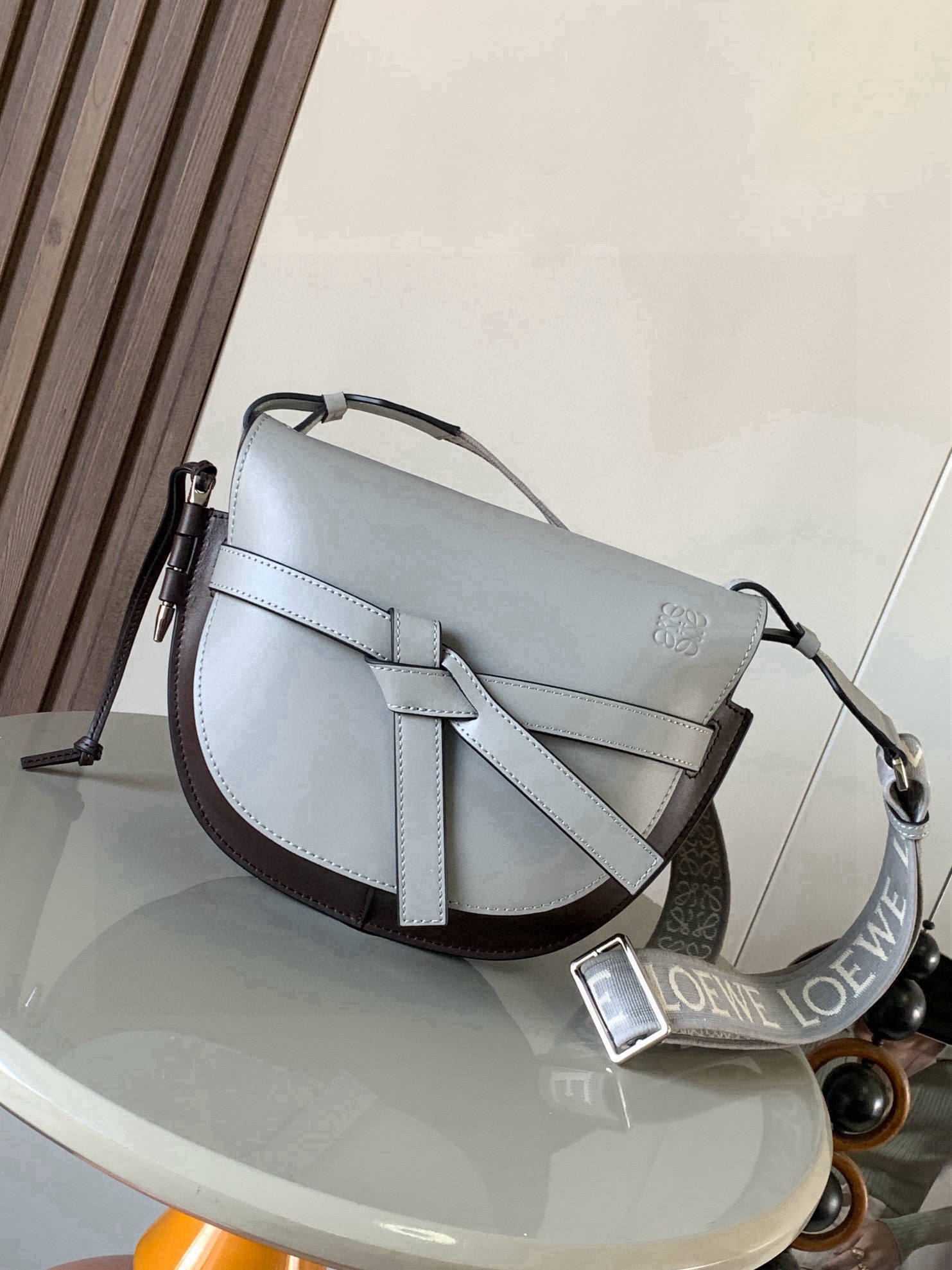 NO:853734,Popular small size 25CM new letter wide shoulder strap saddle bag Gate Duel handbag wide shoulder strap is simply the pen of the soul, giving gate a new life. The bag body is made of soft cow leather, removable and adjustable cowhide embroidered shoulder strap for single shoulder crossbody, waist bag and chest bag. The back and upper body are very elegant. The capacity is also very online. The bow is not only a decoration, but also the only socket on the bag cover. There is only one brand logo in the whole bag.  The bullet-type brass hosel has no other hardware accessories. It is completely made of high-end Western European traditional leather craftsmanship and design style. So it is lightweight and the shoulder straps can be adjusted in length. Girls of any height can handle it. This is very nice. Size 25CM~19CM~11.5CM. Style number 9004. Color: asphalt gray coffee, Loewe, loewe, cowhide19860909爆款小号25CM新款字母宽肩带马鞍包Gate Duel手袋寛肩带简直是灵魂之笔赋予了gate全新的生命包身采用柔软牛皮革精制而成可拆卸调节牛皮提绣花肩带单肩斜挎、腰包 胸包都非常~背上身很显气质 容量也非常在线 蝴蝶结不仅是装饰,也是包盖的唯一插口全包只有一个带品牌精致logo 的子弹头式黄铜插鞘没有其他五金配件,完全是高大上的西欧传统皮革工艺性和设计风格So自重轻便,肩带调节长度,任何身高妹纸都可驾驭,这点很nice了 尺寸25CM~19CM~11.5CM 款号9004 颜色沥青灰咖,罗意威,loewe,cowhide,Bag