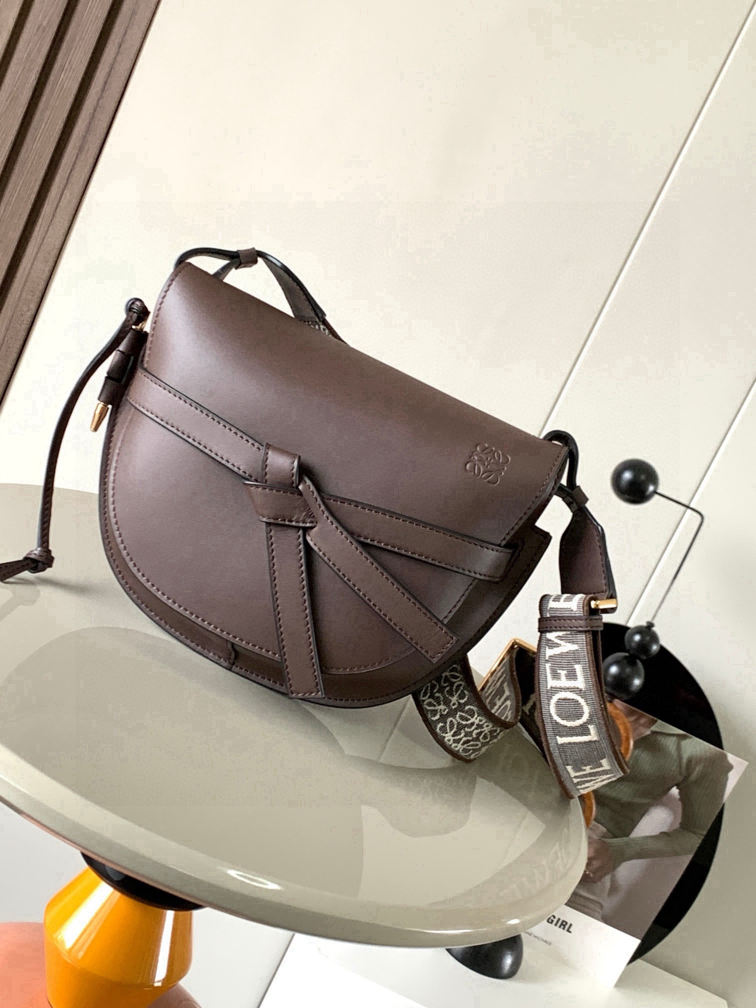 NO:853743,Popular small size 25CM new letter wide shoulder strap saddle bag Gate Duel handbag wide shoulder strap is simply the pen of the soul, giving gate a new life. The bag body is made of soft cow leather, removable and adjustable cowhide embroidered shoulder strap for single shoulder crossbody, waist bag and chest bag. The back and upper body are very elegant. The capacity is also very online. The bow is not only a decoration, but also the only socket on the bag cover. There is only one brand logo in the whole bag.  The bullet-type brass hosel has no other hardware accessories. It is completely made of high-end Western European traditional leather craftsmanship and design style. So it is lightweight and the shoulder straps can be adjusted in length. Girls of any height can control it. This is very nice. Size 25CM~19CM~11.5CM. Style No. 9004. Color: Brown, Loewe, Loewe, Cowhide19860909爆款小号25CM新款字母宽肩带马鞍包Gate Duel手袋寛肩带简直是灵魂之笔赋予了gate全新的生命包身采用柔软牛皮革精制而成可拆卸调节牛皮提绣花肩带单肩斜挎、腰包 胸包都非常~背上身很显气质 容量也非常在线 蝴蝶结不仅是装饰,也是包盖的唯一插口全包只有一个带品牌精致logo 的子弹头式黄铜插鞘没有其他五金配件,完全是高大上的西欧传统皮革工艺性和设计风格So自重轻便,肩带调节长度,任何身高妹纸都可驾驭,这点很nice了 尺寸25CM~19CM~11.5CM 款号9004 颜色啡色,罗意威,loewe,cowhide,Bag