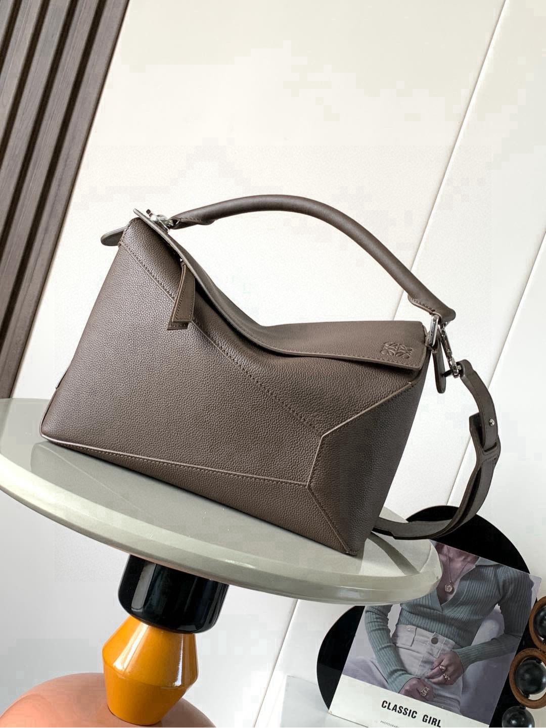 NO:853748,New version of geometric bag 29CMPuzzle handbag ~ imported cowhide Luojia's popular geometric bag Puzzle handbag is the first handbag launched by creative director Jonathan Ande for L0EWE. The rectangular shape and precise cutting technology created Puzzle's unique geometric lines, simple and elegant geometric design, fashionable and cool, sweet and salty original calf leather  The shape of the bag doesn't change, and it feels so comfortable that your upper body instantly looks up. The three-dimensional bag also contains extraordinary capacity, making it a popular item that you can never get enough of!  Size 29CM～19CM～12CM Style No. 9312 Color Snowy Coffee Li, Loewe, loewe, loewe, cowhide19860909新版本几何包29CMPuzzle手袋～原厂进口牛皮 罗家爆款几何包Puzzle 手袋是创意总监乔纳森·安德森Jonathan Ande为 L0EWE 推出的首款手提包长方体形状和精确的切割技术创造了Puzzle 独特的几何线条简约大气的几何设计时髦中带着股酷劲,可甜可盐原厂小牛皮 包型都不变型手感舒适得没话说上身气质立马up～立体包型还蕴藏着非凡的容量是永远都囤不够的热门单品！ 尺寸29CM～19CM～12CM 款号9312 颜色雪咖色荔,罗意威,loewe,loewe,cowhide,Bag
