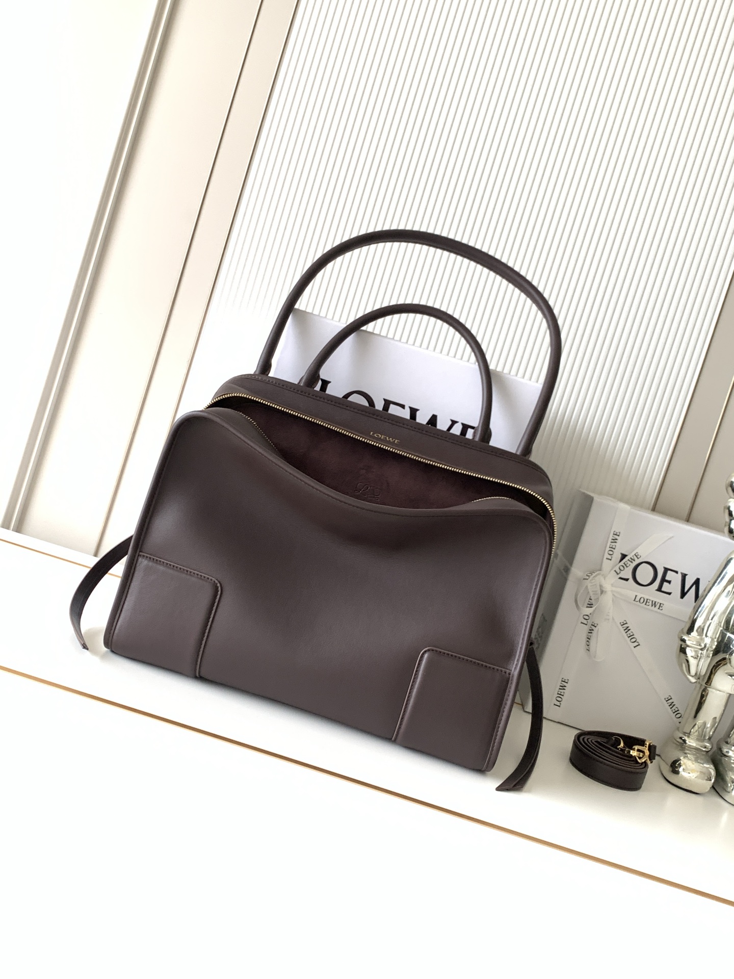 NO:853804,New large size soft cow leather Amazona 180 handbag, same style as Amazona stars  180 reinterprets the legendary handbag in a casual silhouette with a single top handle. The bag features an open design. The main compartment is secured with a hidden buckle and features a detachable shoulder and cross-body strap for a practical style. This large version is made from soft calfskin leather*3  Two ways to carry: Short handle, detachable shoulder and cross-body straps *Zipper with two leather zipper pulls*Two compartments, main compartment with magnetic closure  L embossed brand logo Size 34.5CM～27CM～14CM Style number 9173 Color dark maroon, Loewe, loewe, cowhide19860909新款大号柔软牛皮革 Amazona 180 手袋 明星同款Amazona 180重新诠释传奇手袋呈现休闲廓形,搭配单一顶部提手手袋采用开放式设计主隔层以隐藏扣固定搭配可拆卸肩背和斜挎背带打造实用风格.此大号版本采用柔软牛皮革制成*三种携带方式短提手、可拆卸肩背和斜挎背带*拉链配有两个皮革拉链头*两个隔层,主隔层以磁扣开合*内部扁平口袋*左侧D形环可定制*织物衬里*烫金或烫银,Double L 压纹品牌标志 尺寸34.5CM～27CM～14CM 款号9173 颜色深栗色,罗意威,loewe,cowhide,Bag