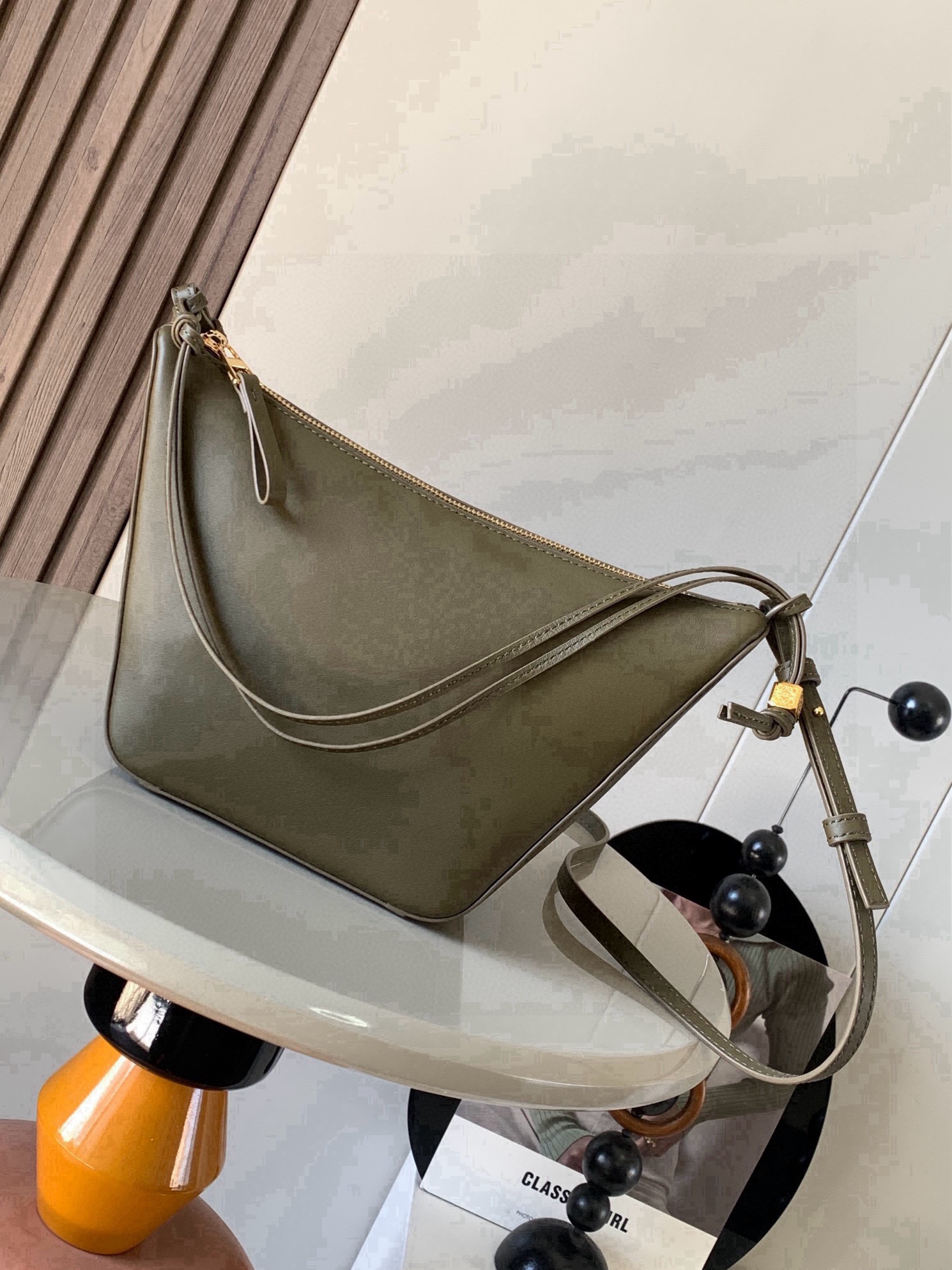 NO:853857,The popular HammockHobo handbag is a new hammock bag/underarm bag, which has three functions: portable, shoulder, and diagonal hanging!  There are many ways to DIY freely. The super versatile Hammock Hobo handbag deconstructs the design of the classic handbag that can easily change its shape, retaining the representative hammock shape, and creates a fashionable, versatile and ergonomic Hobo handbag. The upper body can only be so fragrant!  The two shoulder straps can be worn under the arm or cross-body. The whole body of the bag is super soft. The details include dice beading. The classic short front and long back, the characteristic small round hem, and the whole playful feel. This version is made of classic cow leather. The knotted cow leather strap can be personalized.  Size 28～19～9.5CM Style number 9023 Color Khaki green, Loewe, loewe, cowhide19860909爆款HammockHobo手袋新款吊床包/腋下包,一款三用:手提、肩背、斜挂！可以自由DIY玩法多多,超级百搭Hammock Hobo手袋将经典手袋能轻松改变形状的设计进行解构保留颇具代表性的吊床造型,打造出一款时尚百搭且符合人体工学的 Hobo 手袋上身只能太香了！两根肩带可以腋下也可以斜挎包身全牛皮超级柔软,细节之处有的骰子串珠经典的前短后长,特色的小圆摆,一整个俏皮感此版本采用经典牛皮革制成,打结牛皮革带子可进行个性化设计＊可肩背、斜背或手提＊拉链开合＊牛皮革拉链头＊人字纹棉质帆布衬里＊ 尺寸28～19～9.5CM 款号9023 颜色卡其绿,罗意威,loewe,cowhide,Bag