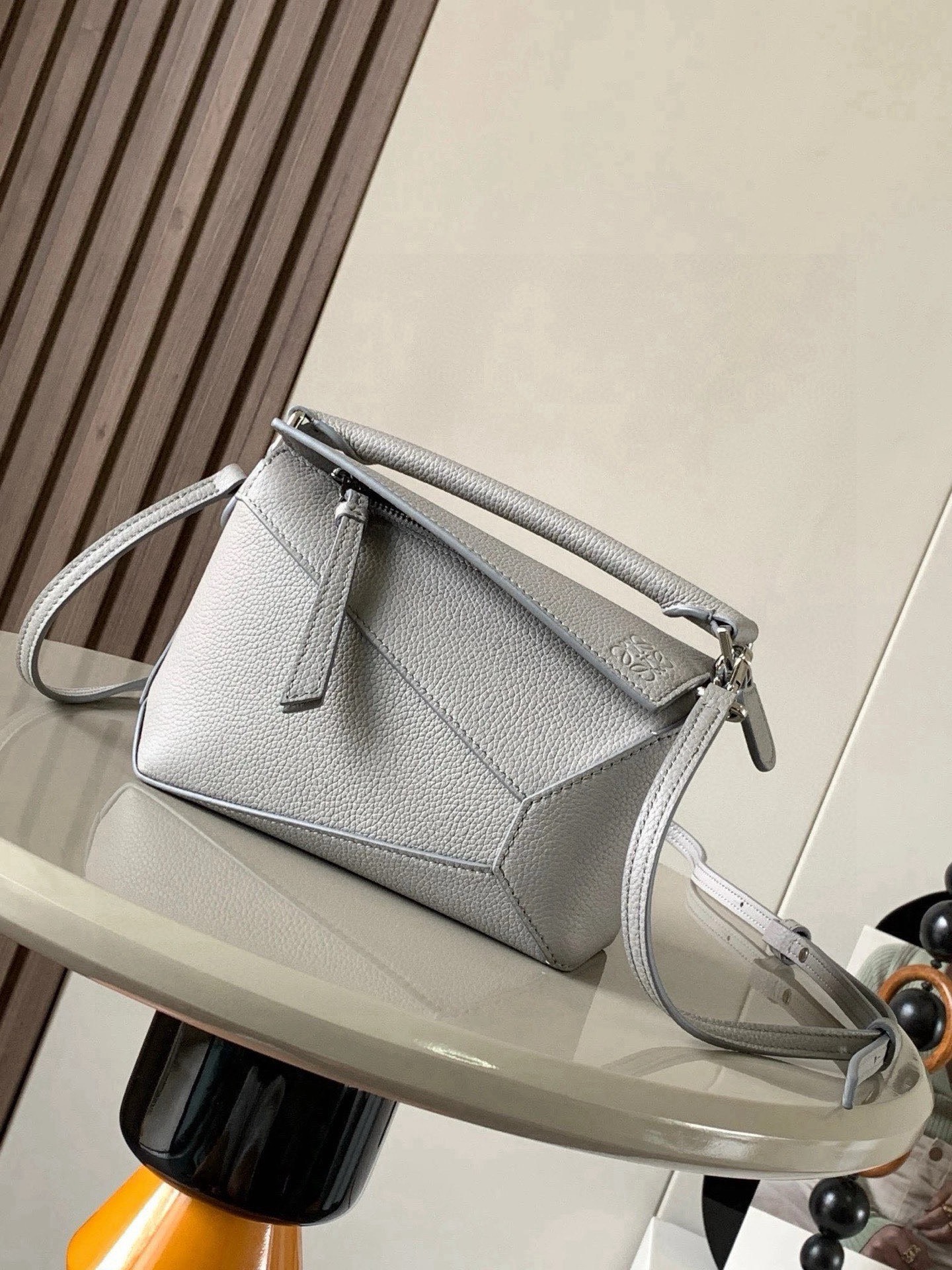 NO:854025,The popular new version of the geometric bag mini 18CM imported Napa calfskin Puzzle handbag is the creative director of Jonathan.  Anderson's first handbag for L0EWE The cuboid shape and precise cutting techniques create the unique geometric lines of the Puzzle. This mini version is crafted from classic cowhide leather The Mini Puzzle  It can accommodate, for example, a small vertical wallet, mobile phones of most sizes (up to 6.1 inches) and sunglasses cases to be carried across the body, on the shoulder, in the hand or by the top handle. The detachable shoulder strap almost ignores the weight of the bag itself, making it practical for carrying mobile phones, small wallets, lipsticks and powders when going out, without any sense of cumbersomeness, and a relaxed and happy life starts from now on (the xs and plus you are most concerned about are all OK). Size 18～12.5～8CM, style number 8003～9310  Color gray,loewe,loewe,wallets,cowhide19860909爆款新版本几何包迷你18CM原厂进口纳帕小牛皮Puzzle手袋是创意总监乔纳森．安德森为 L0EWE 推出的首款手提包长方体形状和精确的切割技术创造了 Puzzle 独特的几何线条.这个迷你版本采用经典牛皮革制成迷你 Puzzle 可以容纳例如一只小号垂直钱包、大多数尺寸的手机（最大6.1英寸）和太阳镜盒斜挎、肩背、手拿或顶部提手携带.可拆卸肩带包包自身重量几乎忽略,炒鸡实用,出门装手机小钱包口红粉饼,毫无累赘感,轻松愉快人生从此开启(你们最关心的xs,plus都ok哈） 尺寸18～12.5～8CM 款号8003～9310 颜色灰色,罗意威,loewe,wallets,cowhide,Bag