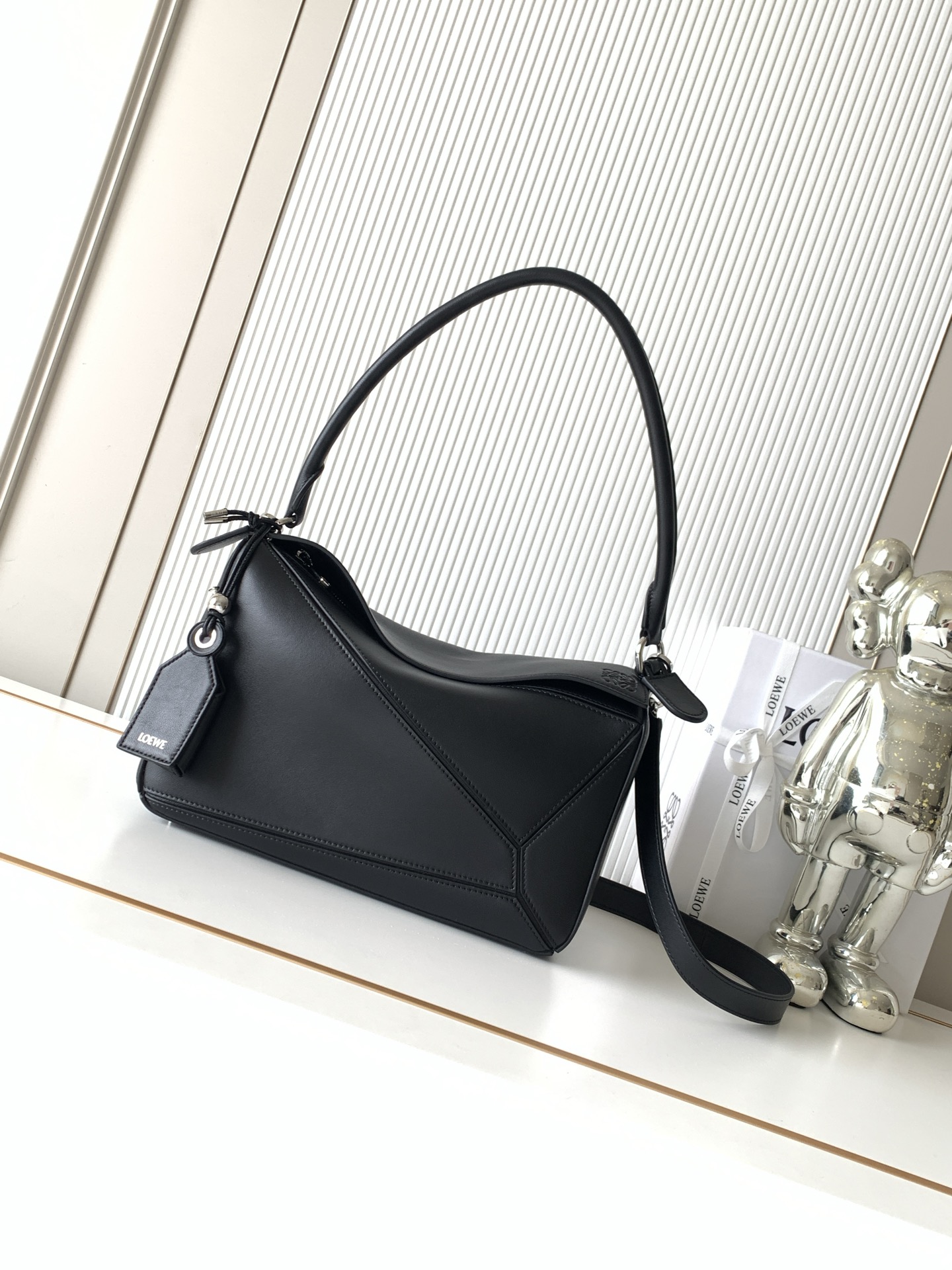 NO:854049,New Geometric Bag Medium Nappa Sheep Leather Featherlight Puzzle Handbag Featherlight Puzzle Unique geometric lines outline the rectangular shape. Soft and lightweight Nappa leather injects a casual and lazy style into the handbag. This version comes with a shoulder strap, which injects new vitality into the design. *Can be worn on the shoulder or cross-body. Embossed, engraved words inside the plaque Size 29CM～19.5CM～12CM Style No. 9177 Color Black, Loewe, loewe, sheepskin19860909新款几何包中号納帕羊皮革 Featherlight Puzzle 手袋Featherlight Puzzle 以别具一格的几何线条勾勒长方体造型柔软轻盈的纳帕皮革为手袋注入随性慵懒的风格此版本配备肩带,为设计注入崭新活力*可肩背或斜挎*可拆卸可调节肩带饰有旋转卡扣“拉链开合,铰接式拉链头*可拆卸烫金或烫银标签饰有隐秘口袋和气球骰子*长方形金属脚钉*纳帕羊皮革衬里*Anagram 压纹、饰牌内部镌刻字样 尺寸29CM～19.5CM～12CM 款号9177 颜色黑色,罗意威,loewe,sheepskin,Bag