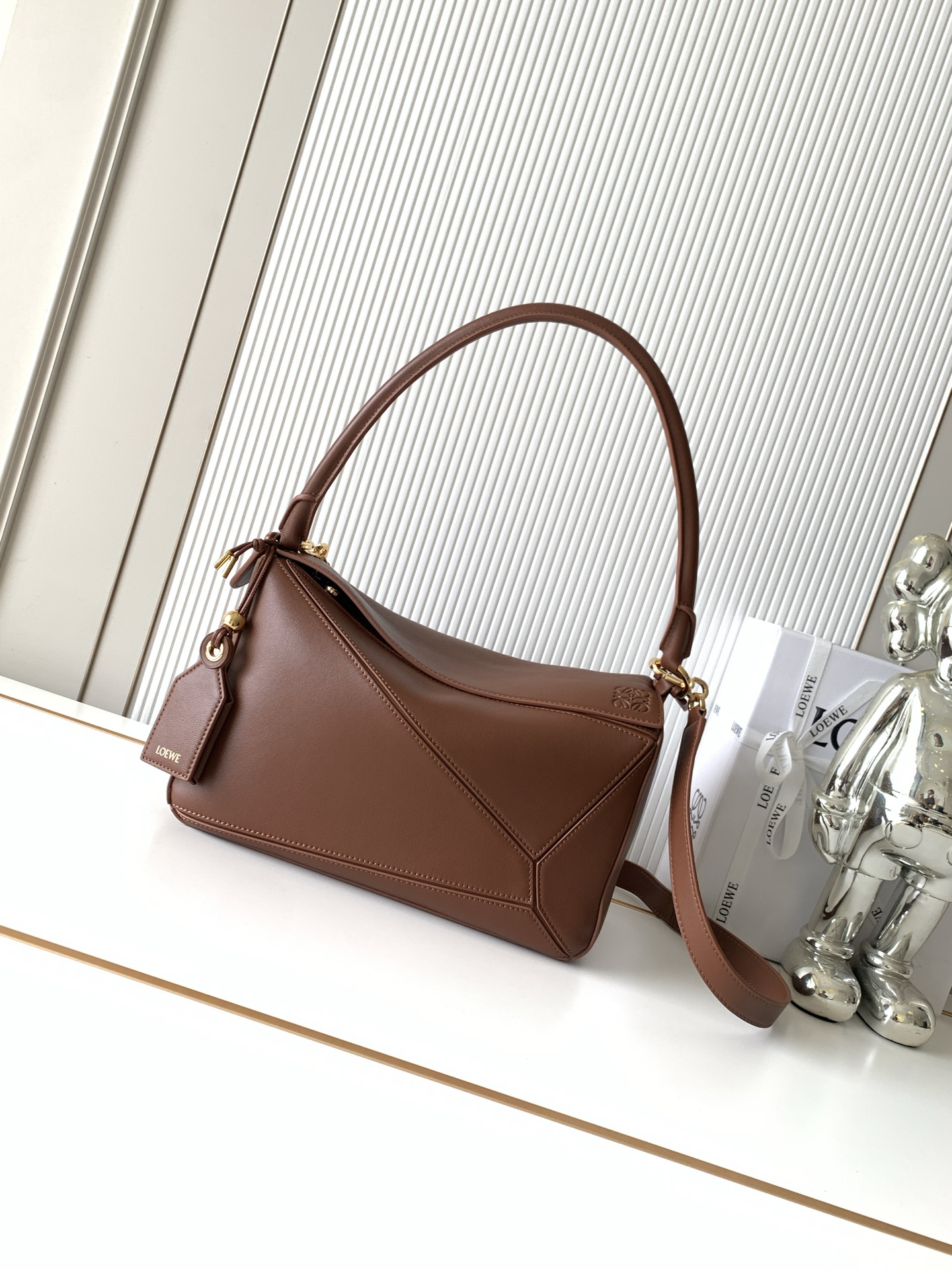 NO:854060,New Geometric Bag Medium Nappa Sheep Leather Featherlight Puzzle Handbag Featherlight Puzzle Unique geometric lines outline the rectangular shape. Soft and lightweight Nappa leather injects a casual and lazy style into the handbag. This version comes with a shoulder strap, which injects new vitality into the design. *Can be worn on the shoulder or cross-body. Embossed, engraved words inside the plaque Size 29CM～19.5CM～12CM Style No. 9177 Color brown, Loewe, loewe, sheepskin19860909新款几何包中号納帕羊皮革 Featherlight Puzzle 手袋Featherlight Puzzle 以别具一格的几何线条勾勒长方体造型柔软轻盈的纳帕皮革为手袋注入随性慵懒的风格此版本配备肩带,为设计注入崭新活力*可肩背或斜挎*可拆卸可调节肩带饰有旋转卡扣“拉链开合,铰接式拉链头*可拆卸烫金或烫银标签饰有隐秘口袋和气球骰子*长方形金属脚钉*纳帕羊皮革衬里*Anagram 压纹、饰牌内部镌刻字样 尺寸29CM～19.5CM～12CM 款号9177 颜色棕色,罗意威,loewe,sheepskin,Bag