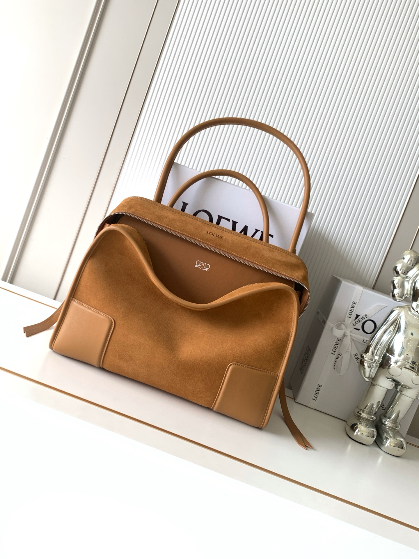 NO:854141,New Large Suede Amazon 180 Handbag Celebrity Same Style Amazon  180 reinterprets the legendary handbag in a casual silhouette with a single top handle. The bag features an open design. The main compartment is secured with a hidden buckle and features a detachable shoulder and cross-body strap for a practical style. This large version is made from soft calfskin leather*3  Two ways to carry: Short handle, detachable shoulder and cross-body straps *Zipper with two leather zipper pulls*Two compartments, main compartment with magnetic closure  L embossed brand logo Size 34.5CM～27CM～14CM Style number 9173 Color yellow brown/honey, Loewe, loewe, cowhide19860909新款大号绒面革Amazona 180 手袋 明星同款Amazona 180重新诠释传奇手袋呈现休闲廓形,搭配单一顶部提手手袋采用开放式设计主隔层以隐藏扣固定搭配可拆卸肩背和斜挎背带打造实用风格.此大号版本采用柔软牛皮革制成*三种携带方式短提手、可拆卸肩背和斜挎背带*拉链配有两个皮革拉链头*两个隔层,主隔层以磁扣开合*内部扁平口袋*左侧D形环可定制*织物衬里*烫金或烫银,Double L 压纹品牌标志 尺寸34.5CM～27CM～14CM 款号9173 颜色黄棕/蜂蜜色,罗意威,loewe,cowhide,Bag