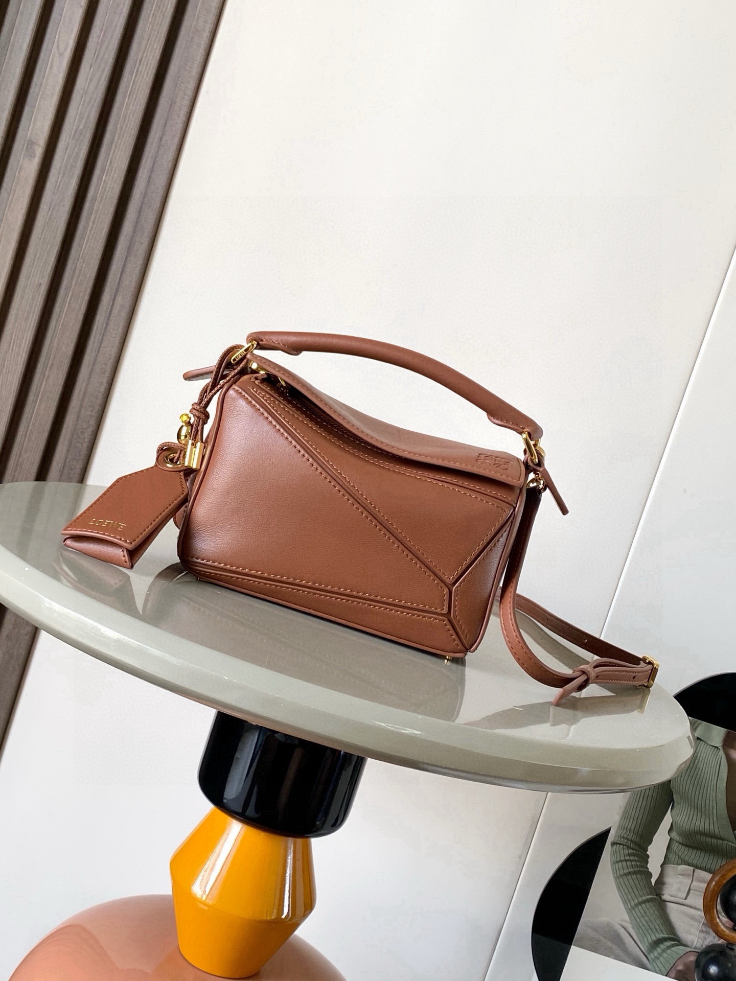 NO:854164,New version of the Geometric Bag Mini Nappa Lamb Leather Featherlight Puzzle Bag,  The original imported Napa calfskin outlines a cuboid shape with unique geometric lines. The soft and lightweight Napa leather injects a casual and lazy style into the handbag. *Can be carried on the shoulder, crossbody or handheld*Detachable and adjustable shoulder strap, decorated with rotating buckle*Zipper  Closure, articulated zipper pull * One external zipped back pocket, one internal slip pocket * Removable, with secret pocket and balloon dice * Rectangular metal feet * This smaller version is made from soft Nappa calf leather * Small Puzzle  Can accommodate, for example, a large wallet, all sizes of mobile phones and sunglasses, carried diagonally, on the shoulder, in hand or by top handle *Detachable Color Brown Style No. 9098 Size 18CM～12.5CM～7.5CM, Loewe, loewe, wallets, cowhide, sheepskin19860909新版本几何包迷你纳帕羊皮革 Featherlight Puzzle 手袋, 原厂进口纳帕小牛皮以别具一格的几何线条勾勒长方体造型.柔软轻盈的纳帕皮革为手袋注入随性慵懒的风格.*可肩背、斜挎或手提*可拆卸可调节肩带,饰有旋转卡扣*拉链开合,铰接式拉链头*一个外部拉链后袋,一个内部插袋*可拆卸,饰有隐秘口袋和气球骰子*长方形金属脚钉*这个小尺寸版本采用柔软纳帕小牛皮革制成＊小号Puzzle 可以容纳例如一只大号钱包所有尺寸的手机和太阳镜斜、肩背、手拿或顶部提手携带＊可拆卸 颜色棕色 款号9098 尺寸18CM～12.5CM～7.5CM,罗意威,loewe,wallets,cowhide,sheepskin,Bag