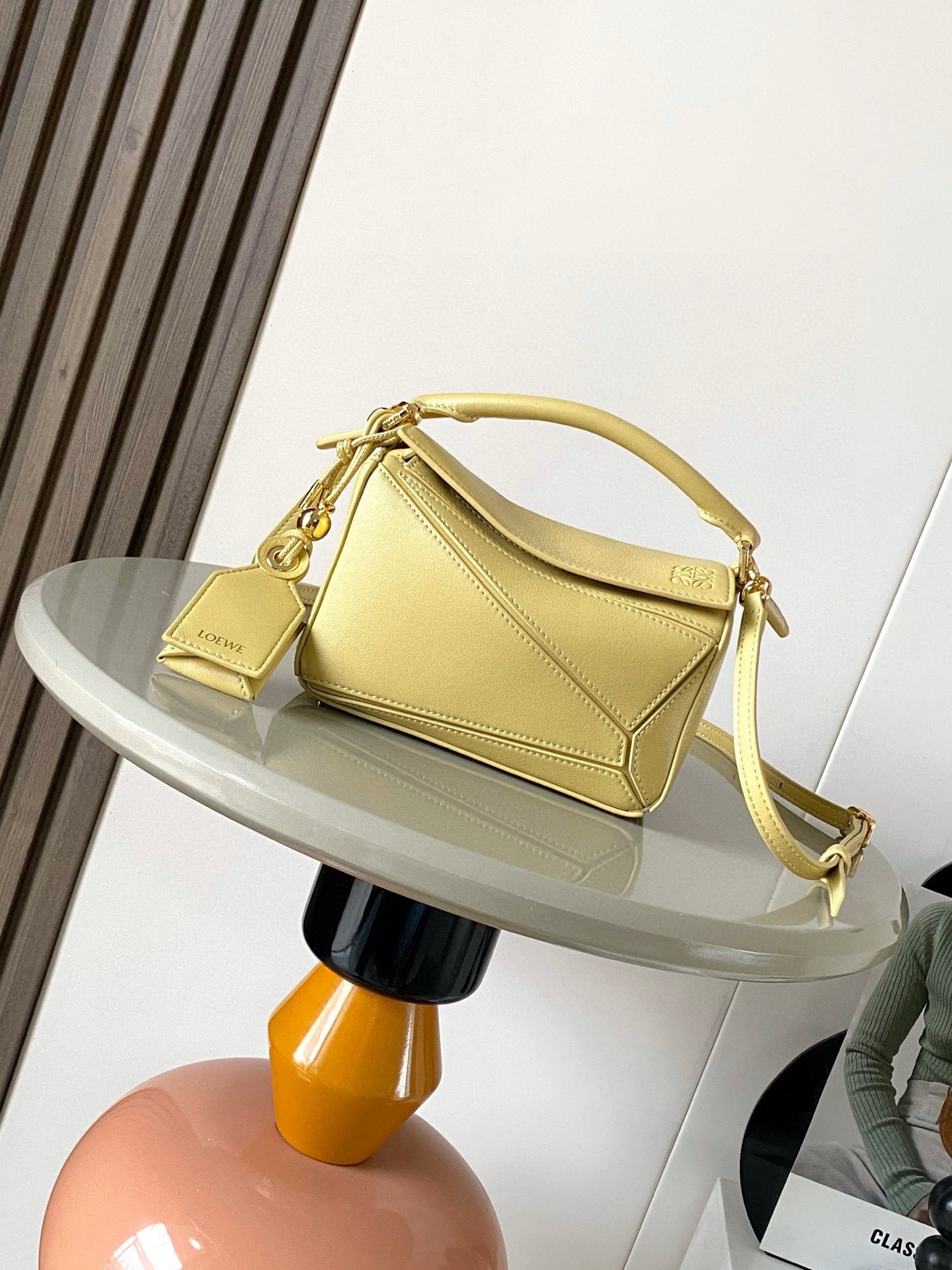 NO:854198,New version of the Geometric Bag Mini Nappa Lamb Leather Featherlight Puzzle Bag,  The original imported Napa calfskin outlines a cuboid shape with unique geometric lines. The soft and lightweight Napa leather injects a casual and lazy style into the handbag. *Can be carried on the shoulder, crossbody or handheld*Detachable and adjustable shoulder strap, decorated with rotating buckle*Zipper  Closure, articulated zipper pull * One external zipped back pocket, one internal slip pocket * Removable, with secret pocket and balloon dice * Rectangular metal feet * This smaller version is made from soft Nappa calf leather * Small Puzzle  Can hold, for example, a large wallet, all sizes of mobile phones and sunglasses. Can be carried diagonally, on the shoulder, in the hand or by the top handle. *Detachable. Color butter. Style No. 9098. Size 18CM～12.5CM～7.5CM. Loewe, loewe, wallets, cowhide, sheepskin19860909新版本几何包迷你纳帕羊皮革 Featherlight Puzzle 手袋, 原厂进口纳帕小牛皮以别具一格的几何线条勾勒长方体造型.柔软轻盈的纳帕皮革为手袋注入随性慵懒的风格.*可肩背、斜挎或手提*可拆卸可调节肩带,饰有旋转卡扣*拉链开合,铰接式拉链头*一个外部拉链后袋,一个内部插袋*可拆卸,饰有隐秘口袋和气球骰子*长方形金属脚钉*这个小尺寸版本采用柔软纳帕小牛皮革制成＊小号Puzzle 可以容纳例如一只大号钱包所有尺寸的手机和太阳镜斜、肩背、手拿或顶部提手携带＊可拆卸 颜色黄油色 款号9098 尺寸18CM～12.5CM～7.5CM,罗意威,loewe,wallets,cowhide,sheepskin,Bag