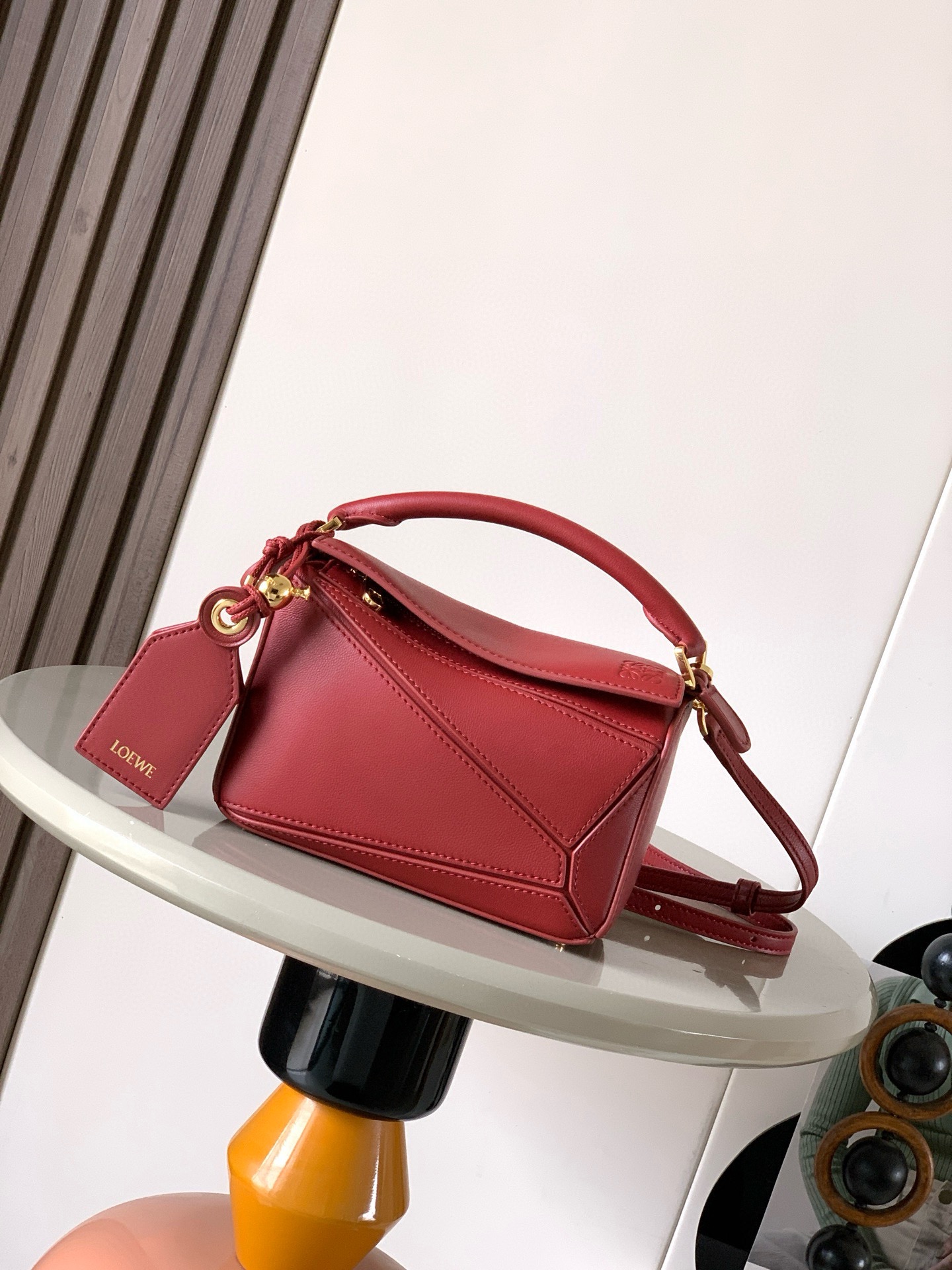 NO:854208,New version of the Geometric Bag Mini Nappa Lamb Leather Featherlight Puzzle Bag,  The original imported Napa calfskin outlines a cuboid shape with unique geometric lines. The soft and lightweight Napa leather injects a casual and lazy style into the handbag. *Can be carried on the shoulder, crossbody or handheld*Detachable and adjustable shoulder strap, decorated with rotating buckle*Zipper  Closure, articulated zipper pull * One external zipped back pocket, one internal slip pocket * Removable, with secret pocket and balloon dice * Rectangular metal feet * This smaller version is made from soft Nappa calf leather * Small Puzzle  Can hold, for example, a large wallet, mobile phones and sunglasses of all sizes. Can be carried diagonally, on the shoulder, in the hand or by the top handle19860909新版本几何包迷你纳帕羊皮革 Featherlight Puzzle 手袋, 原厂进口纳帕小牛皮以别具一格的几何线条勾勒长方体造型.柔软轻盈的纳帕皮革为手袋注入随性慵懒的风格.*可肩背、斜挎或手提*可拆卸可调节肩带,饰有旋转卡扣*拉链开合,铰接式拉链头*一个外部拉链后袋,一个内部插袋*可拆卸,饰有隐秘口袋和气球骰子*长方形金属脚钉*这个小尺寸版本采用柔软纳帕小牛皮革制成＊小号Puzzle 可以容纳例如一只大号钱包所有尺寸的手机和太阳镜斜、肩背、手拿或顶部提手携带＊可拆卸 颜色深红 款号9098 尺寸18CM～12.5CM～7.5CM,罗意威,loewe,wallets,cowhide,sheepskin,Bag