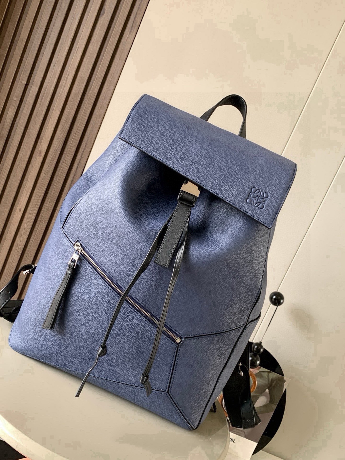 NO:854267,Puzzle Backpack Backpack Soft Grained Calf Leather Military Backpack Backpack is a spacious and versatile backpack style. The backpack is made of soft grained calfskin and classic calfskin. It is very comfortable to the touch. It is not only durable but also has a shoulder-stretching design. This backpack adopts Loewe's classic geometric design without a large logo.  You can directly recognize the low-key and connotative content by displaying it. Its cubic shape is unique and innovative, and the drawstring bag mouth is equipped with a buckle switch. It is safe and practical. The bag is basically versatile. Not only that, it also has a large capacity suitable for commuting and travel. Fashion and practicality coexist!  Size 33～44.5～16CM Style number 9031 Color blue, Loewe, loewe, backpacks, cowhide19860909puzzle Backpack双肩包柔软粒面牛皮革军用背包双肩包是一种宽敞且用途广泛的背包款双肩包选择的是用柔软粒面小牛皮与经典小牛皮精制而成触感非常的舒适,不仅抗造而且还不勒肩膀设计这款双肩包采用了罗意威家的经典几何设计不用大幅度的 logo 展示就可以直接辨认低调有内涵.其立方体的造型独特而创新,抽绳包口搭配搭扣开关,安全又实用包包基本百搭,不仅如此它还有超大容量适用于通勤和差旅时尚与实用并存！ 尺寸33～44.5～16CM 款号9031 颜色蓝色,罗意威,loewe,backpacks,cowhide,Bag