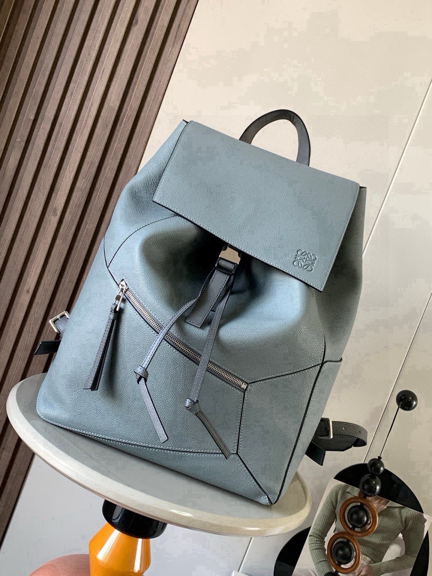 NO:854276,Puzzle Backpack Backpack Soft Grained Calf Leather Military Backpack Backpack is a spacious and versatile backpack style. The backpack is made of soft grained calfskin and classic calfskin. It is very comfortable to the touch. It is not only durable but also has a shoulder-stretching design. This backpack adopts Loewe's classic geometric design without a large logo.  You can directly recognize the low-key and connotative content by displaying it. Its cubic shape is unique and innovative, and the drawstring bag mouth is equipped with a buckle switch. It is safe and practical. The bag is basically versatile. Not only that, it also has a large capacity suitable for commuting and travel. Fashion and practicality coexist!  Size 33～44.5～16CM Style No. 9031 Color Bronze, Loewe, loewe, backpacks, cowhide19860909puzzle Backpack双肩包柔软粒面牛皮革军用背包双肩包是一种宽敞且用途广泛的背包款双肩包选择的是用柔软粒面小牛皮与经典小牛皮精制而成触感非常的舒适,不仅抗造而且还不勒肩膀设计这款双肩包采用了罗意威家的经典几何设计不用大幅度的 logo 展示就可以直接辨认低调有内涵.其立方体的造型独特而创新,抽绳包口搭配搭扣开关,安全又实用包包基本百搭,不仅如此它还有超大容量适用于通勤和差旅时尚与实用并存！ 尺寸33～44.5～16CM 款号9031 颜色青铜色,罗意威,loewe,backpacks,cowhide,Bag