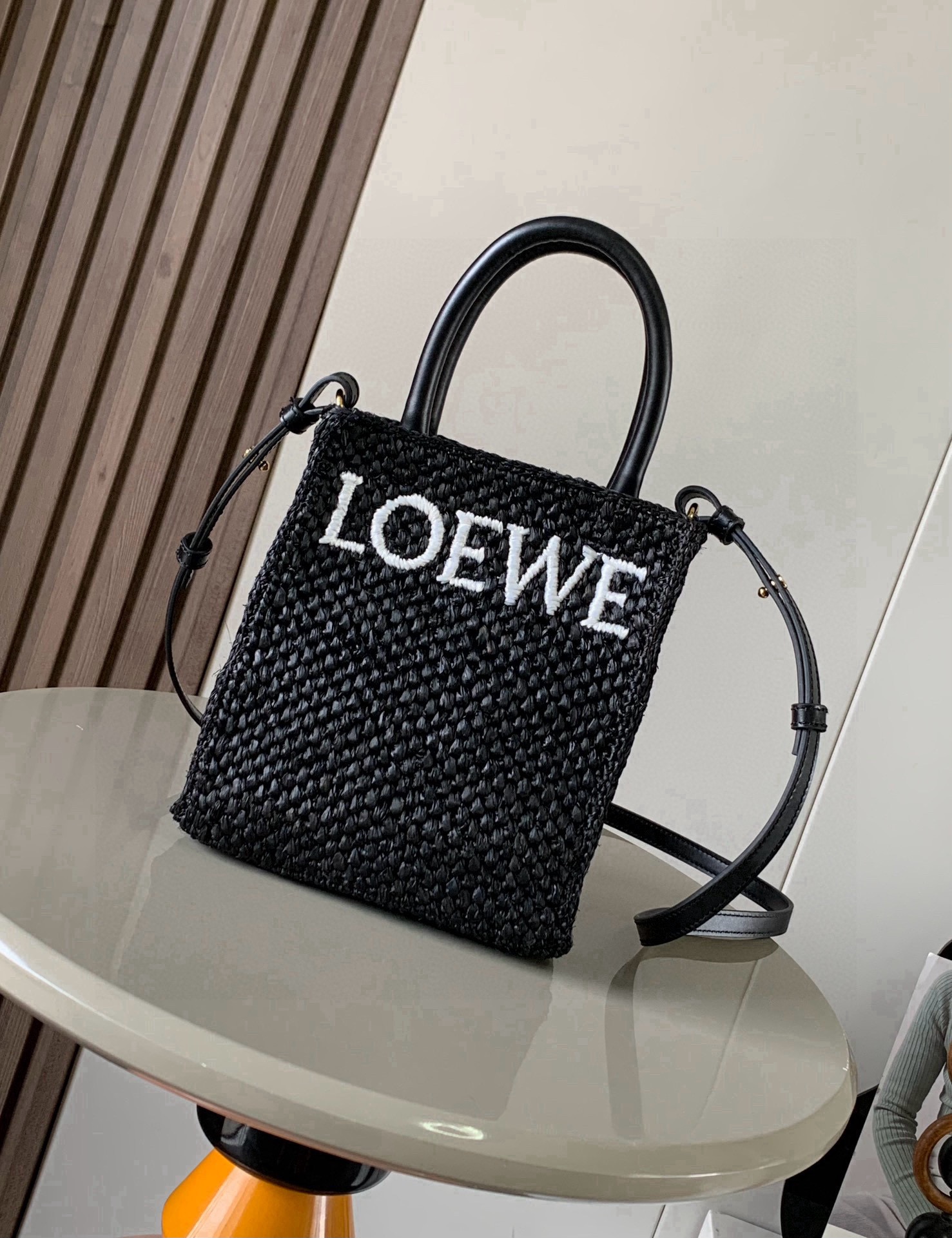 NO:854422,Raffia Standard A5 Tote Handbag Standard Tote handbag is simple and eye-catching. It has a simple silhouette, a practical shape and a simple top handle. This A5 version is made of raffia fiber. It has a cow leather top handle and is decorated with a contrasting LOEWE logo. * Carry by hand or shoulder * Detachable and adjustable strap. Suitable for vacation, leisure, daily commuting. Style No. 8016 Size 21.5cm～17cm～6cm  Color black,loewe,loewe,loewe,cowhide19860909酒椰纤维标准A5 Tote 手袋Standard Tote 手袋简约而引人注目拥有简洁的廓形实用的形状和简单的顶部提手这个A5版本采用酒椰纤维制成配有牛皮革顶部提手饰有对比色 LOEWE 标记.＊手拎或肩背＊可拆卸可调节带子度假休闲日常通勤搭配皆可 款号8016 尺寸21.5cm～17cm～6cm 颜色黑色,罗意威,loewe,loewe,cowhide,Bag