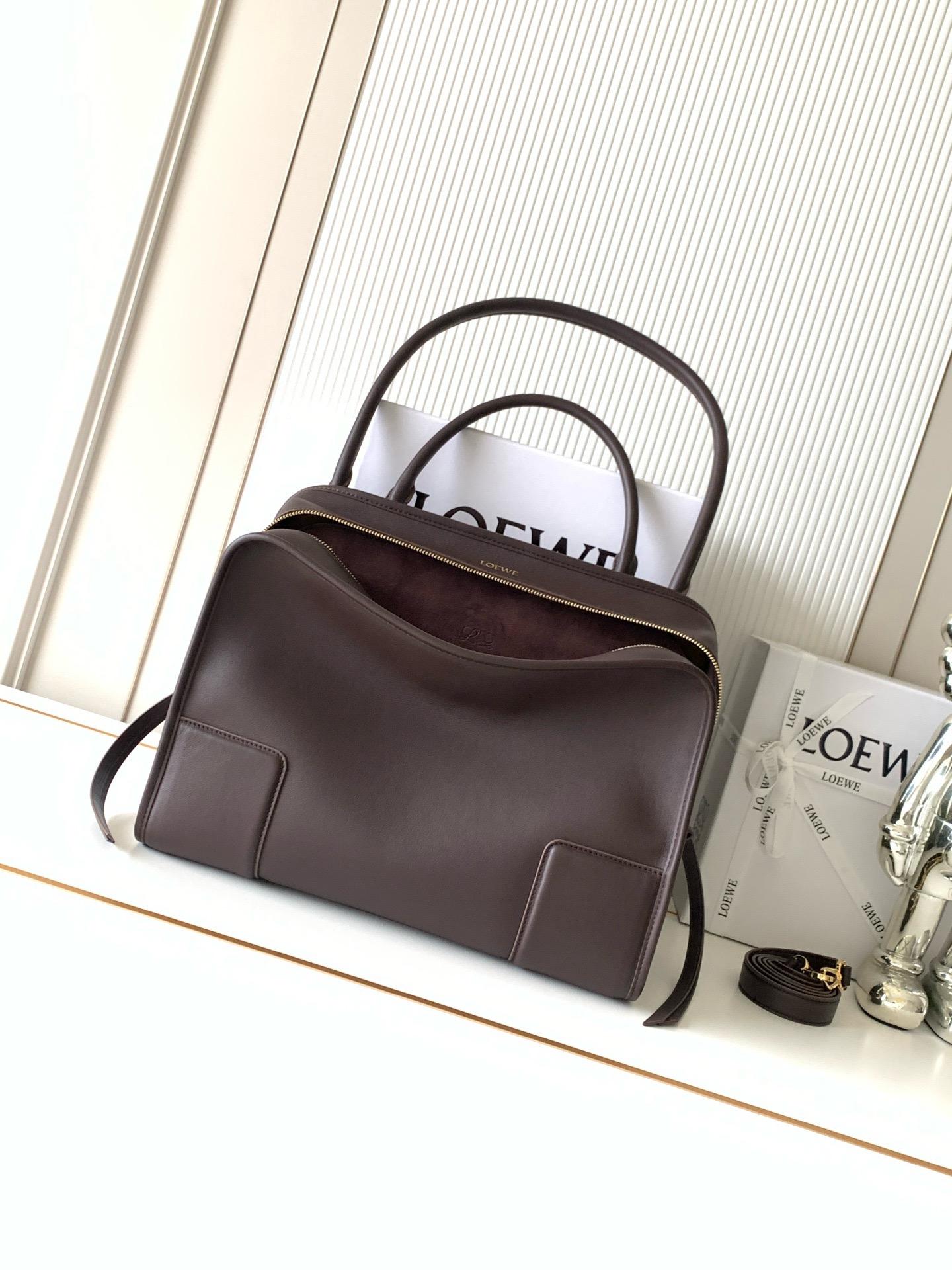 NO:854499,New large size soft cow leather Amazona 180 handbag, same style as Amazona stars  180 reinterprets the legendary handbag in a casual silhouette with a single top handle. The bag features an open design. The main compartment is secured with a hidden buckle and features a detachable shoulder and cross-body strap for a practical style. This large version is made from soft calfskin leather*3  Two ways to carry: Short handle, detachable shoulder and cross-body straps *Zipper with two leather zipper pulls*Two compartments, main compartment with magnetic closure  L embossed brand logo Size 34.5CM～27CM～14CM Style number 9173 Color dark maroon, Loewe, loewe, cowhide19860909新款大号柔软牛皮革 Amazona 180 手袋 明星同款Amazona 180重新诠释传奇手袋呈现休闲廓形,搭配单一顶部提手手袋采用开放式设计主隔层以隐藏扣固定搭配可拆卸肩背和斜挎背带打造实用风格.此大号版本采用柔软牛皮革制成*三种携带方式短提手、可拆卸肩背和斜挎背带*拉链配有两个皮革拉链头*两个隔层,主隔层以磁扣开合*内部扁平口袋*左侧D形环可定制*织物衬里*烫金或烫银,Double L 压纹品牌标志 尺寸34.5CM～27CM～14CM 款号9173 颜色深栗色,罗意威,loewe,cowhide,Bag