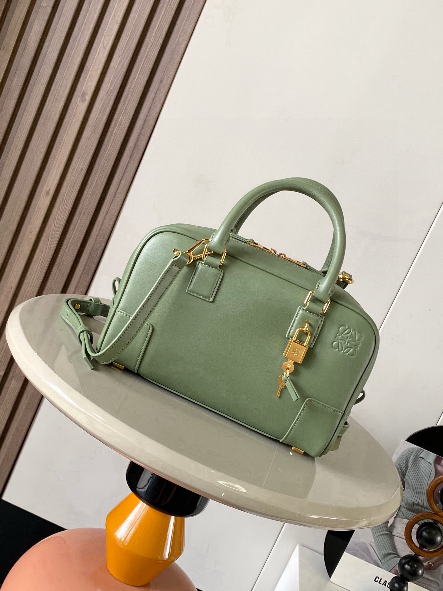 NO:854472,Amazona 23 Bag in Nappa Cow Leather The Amazona is LOEWE's iconic bag, originally launched in the 1970s as a top-handle soft-structure bag. This Nappa cow leather version is updated with refined proportions and details, including an Anagram  Engraved padlock * Cross-body, shoulder or top handle carry * Detachable and adjustable shoulder strap * Dual zipper closure * Cow leather zipper pull * Internal zip compartment and snap-fastened slip pocket * Mini pocket for padlock keys * Protective metal feet at base * Can be customized with shoulder strap and personalized charms * Gold suede lining * Anagram embossed  Size 23cm～10cm～15cm Style number 9078 Color green pattern, Loewe, loewe, loewe, cowhide19860909纳帕牛皮革 Amazona 23 手袋Amazona 是 LOEWE 的标志性手袋,最初于1970年代作为顶部提手软结构手袋推出这款纳帕牛皮革版本更新了精致的比例和细节,包括一个 Anagram 雕刻挂锁＊斜挎、肩背或顶部提手携带＊可拆卸可调节肩带＊双拉链开合＊牛皮革拉链头＊内部拉链隔层和按扣固定的插袋＊用于存放挂锁钥匙的迷你口袋＊底部保护性金属脚＊可以使用肩带和个性化挂饰进行定制＊金色绒面革衬里＊ Anagram 压纹 尺寸23cm～10cm～15cm 款号9078 颜色绿色纹,罗意威,loewe,loewe,cowhide,Bag