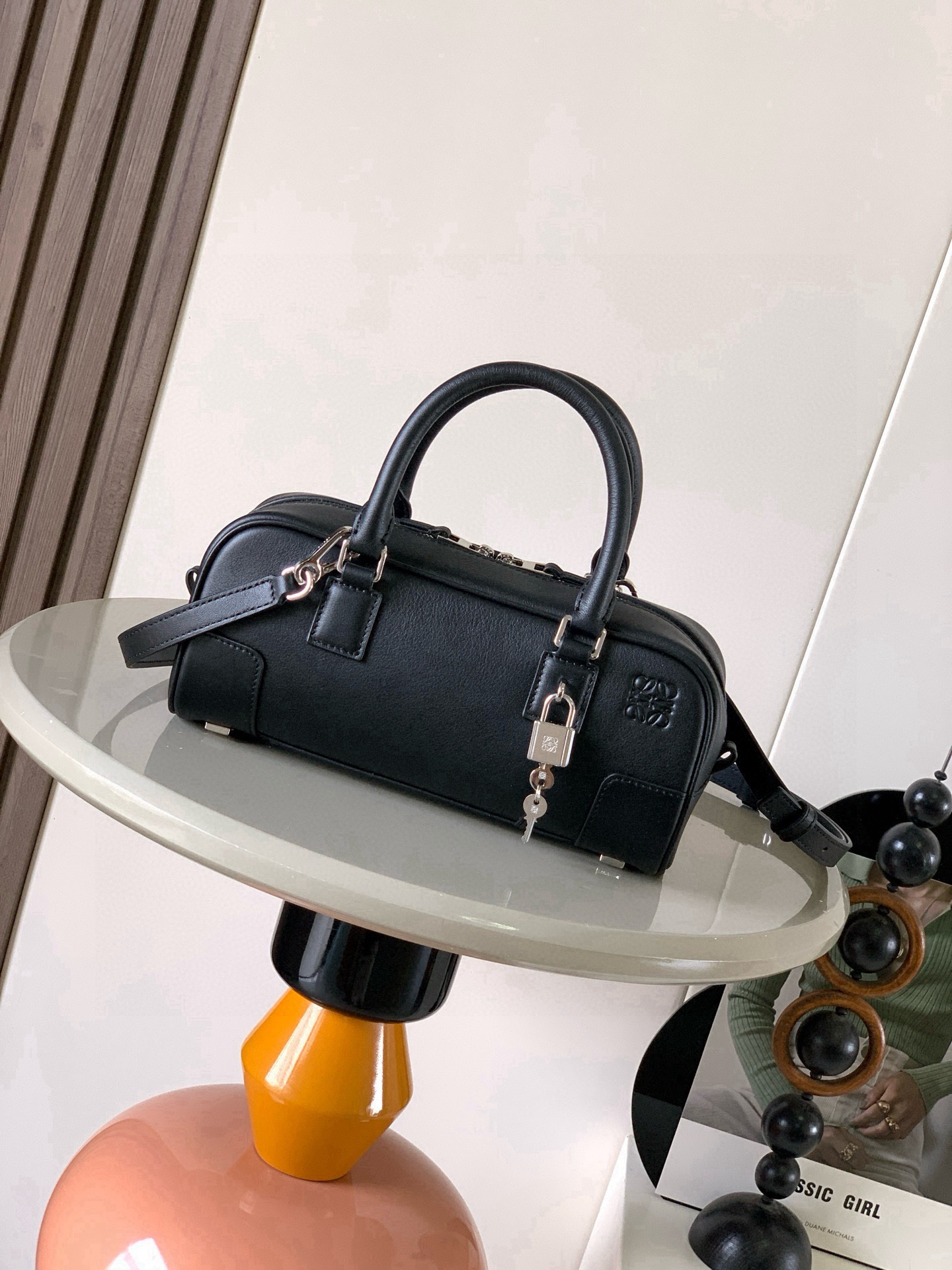 NO:854520,The new celebrity handbag Amazona is an iconic handbag originally launched by LOEWE in the 1970s, featuring exquisite proportions and key details including the Anagram  The short style with engraved padlock is made of nappa cow leather * Can be worn on the shoulder, cross-body or hand-held * Detachable and adjustable shoulder strap * Zipper closure, cow leather zipper pull * An internal zipper compartment, a slip pocket, a padlock key storage bag * The bottom of the bag is protected by metal feet * Gold suede lining * Anagram embossed Size 23cm～10cm～11cm Style No. 9085  Color black silver lock,loewe,loewe,loewe,cowhide19860909新款明星同款手袋 Amazona 是 LOEWE 最初于1970年代推出的标志性手袋,采用精致比例和关键细节包括 Anagram 镌刻挂锁短款以纳帕牛皮革打造而成＊可肩背、斜挎或手提＊可拆卸可调节肩带＊拉链开合,牛皮革拉链头＊一个内部拉链隔层一个插袋,一个挂锁钥匙收纳袋＊包底以金属脚钉保护＊金色绒面革衬里* Anagram 压纹 尺寸23cm～10cm～11cm 款号9085 颜色黑色银锁,罗意威,loewe,loewe,cowhide,Bag
