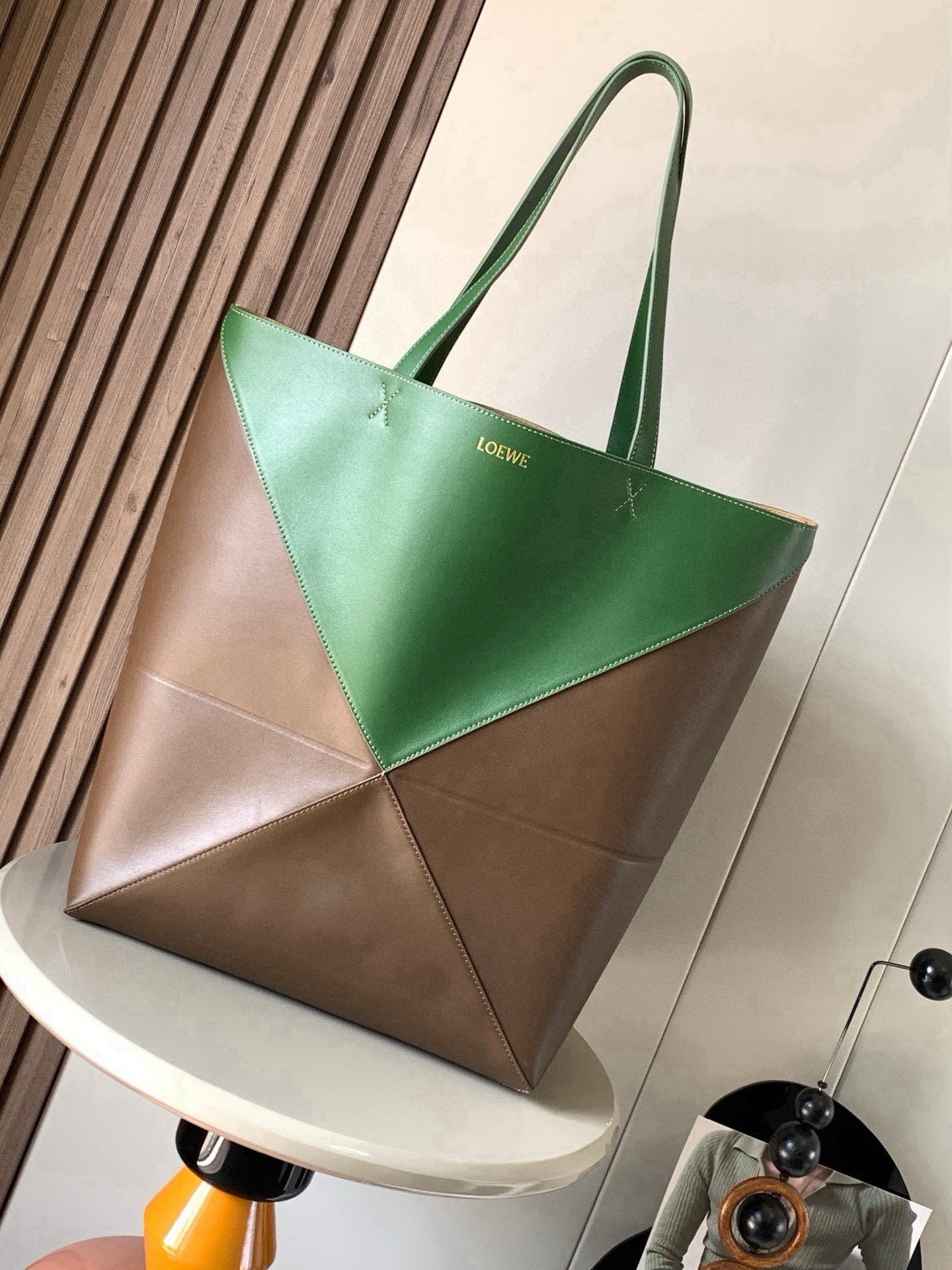 NO:854608,Large new shiny cow leather shopping bag puzzle Fold handbag large geometric pattern It has been a long time since I have seen such a practical and design tote bag. This continues the geometric aesthetics of the Puzzle series and is inspired by origami bags. This Puzzle Fold tote  I freely switch between three-dimensional and flat upper body sizes for your reference. The large size has a more friendly capacity, and the small size is very cute. The leather is very delicate and shiny. It is super light in weight. In addition, it can be folded, which is perfect for commuting with a computer, or for people like me who often travel on business and can easily store it in their luggage. Puzzle  The Fold handbag draws inspiration from the geometric lines of the brand's classic handbag series and uses creative ingenuity to reinterpret it into a fashionable tote bag that can be completely folded and is a good travel companion. This large version is made of soft glossy cowhide. Size 42CM ~ 41CM ~ 18CM. Style number 9033. Color amber hunter green, Loewe, loewe, totes, cowhide19860909大号新款亮面牛皮革购物袋puzzle Fold手袋大号几何图形玩出花了很久没见过这么实用又设计感满满的托特包了这款延续了Puzzle系列的几何美学以折纸包为灵感,让这只 Puzzle Fold tote 在立体和平面随意切换上身了两个尺码给大家参考哦大号容量更友好,小号很可爱,皮质都很细腻光泽本身自重超轻,外加可以折叠太适合平时带电脑通勤,或是像我一样经常出差旅行不费力的收纳进行李箱,Puzzle Fold手袋从品牌经典手袋系列的几何线条汲取灵感运用创意巧思将其重新诠释为一款时尚的托特袋,能完全折叠是旅行良伴.这个大号版本采用柔软的亮面牛皮革打造 尺寸42CM～41CM～18CM 款号9033 颜色琥珀猎人绿,罗意威,loewe,totes,cowhide,Bag
