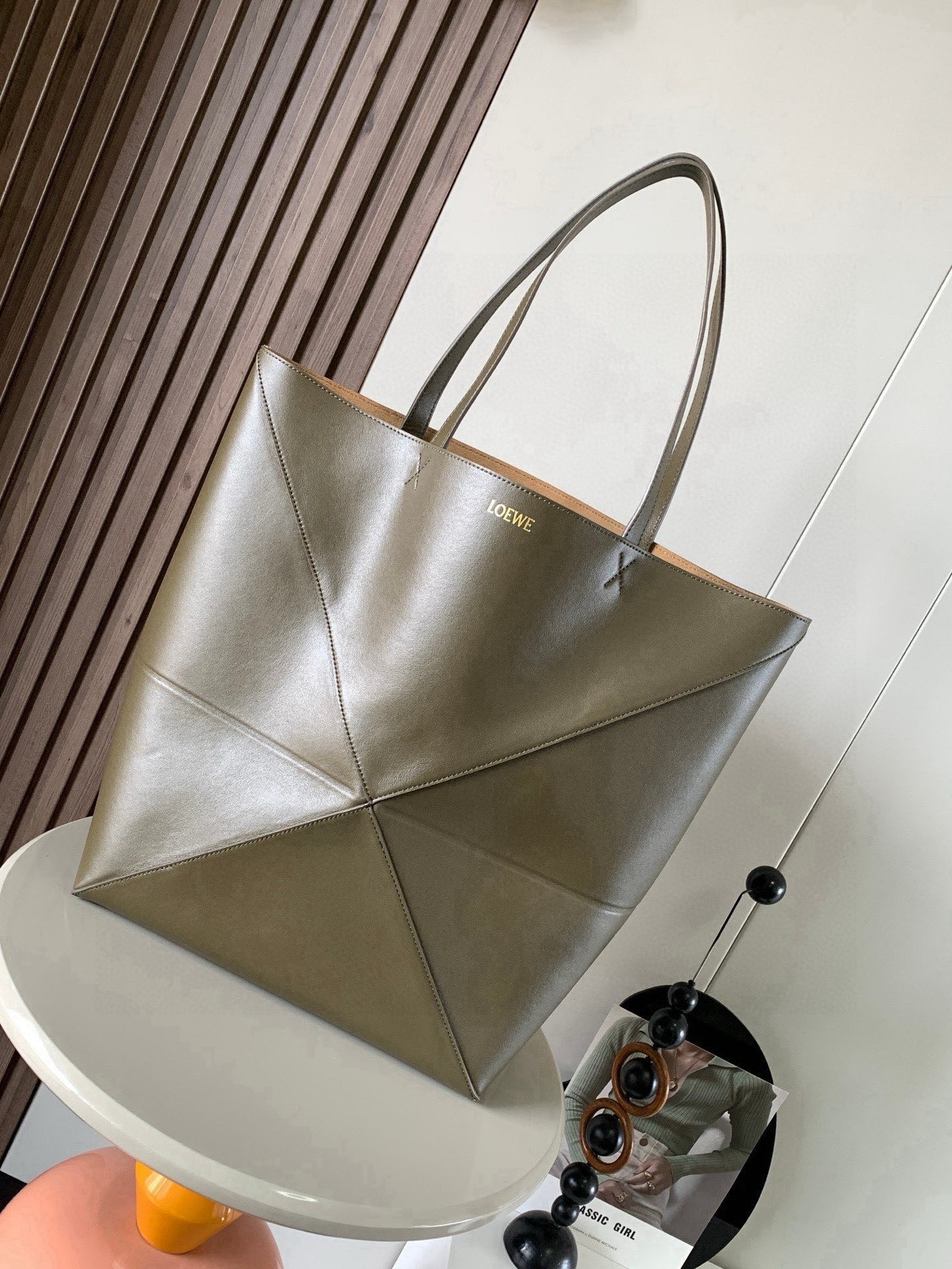 NO:854651,Large new shiny cow leather shopping bag puzzle Fold handbag large geometric pattern It has been a long time since I have seen such a practical and design tote bag. This continues the geometric aesthetics of the Puzzle series and is inspired by origami bags. This Puzzle Fold tote  I freely switch between three-dimensional and flat upper body sizes for your reference. The large size has a more friendly capacity, and the small size is very cute. The leather is very delicate and shiny. It is super light in weight. In addition, it can be folded, which is perfect for commuting with a computer, or for people like me who often travel on business and can easily store it in their luggage. Puzzle  The Fold handbag draws inspiration from the geometric lines of the brand's classic handbag series and uses creative ingenuity to reinterpret it into a fashionable tote bag that can be completely folded and is a good travel companion. This large version is made of soft glossy cow leather. Size 42CM～41CM～18CM. Style No. 9033. Color: khaki green, Loewe, loewe, totes, cowhide19860909大号新款亮面牛皮革购物袋puzzle Fold手袋大号几何图形玩出花了很久没见过这么实用又设计感满满的托特包了这款延续了Puzzle系列的几何美学以折纸包为灵感,让这只 Puzzle Fold tote 在立体和平面随意切换上身了两个尺码给大家参考哦大号容量更友好,小号很可爱,皮质都很细腻光泽本身自重超轻,外加可以折叠太适合平时带电脑通勤,或是像我一样经常出差旅行不费力的收纳进行李箱,Puzzle Fold手袋从品牌经典手袋系列的几何线条汲取灵感运用创意巧思将其重新诠释为一款时尚的托特袋,能完全折叠是旅行良伴.这个大号版本采用柔软的亮面牛皮革打造 尺寸42CM～41CM～18CM 款号9033 颜色卡其绿,罗意威,loewe,totes,cowhide,Bag