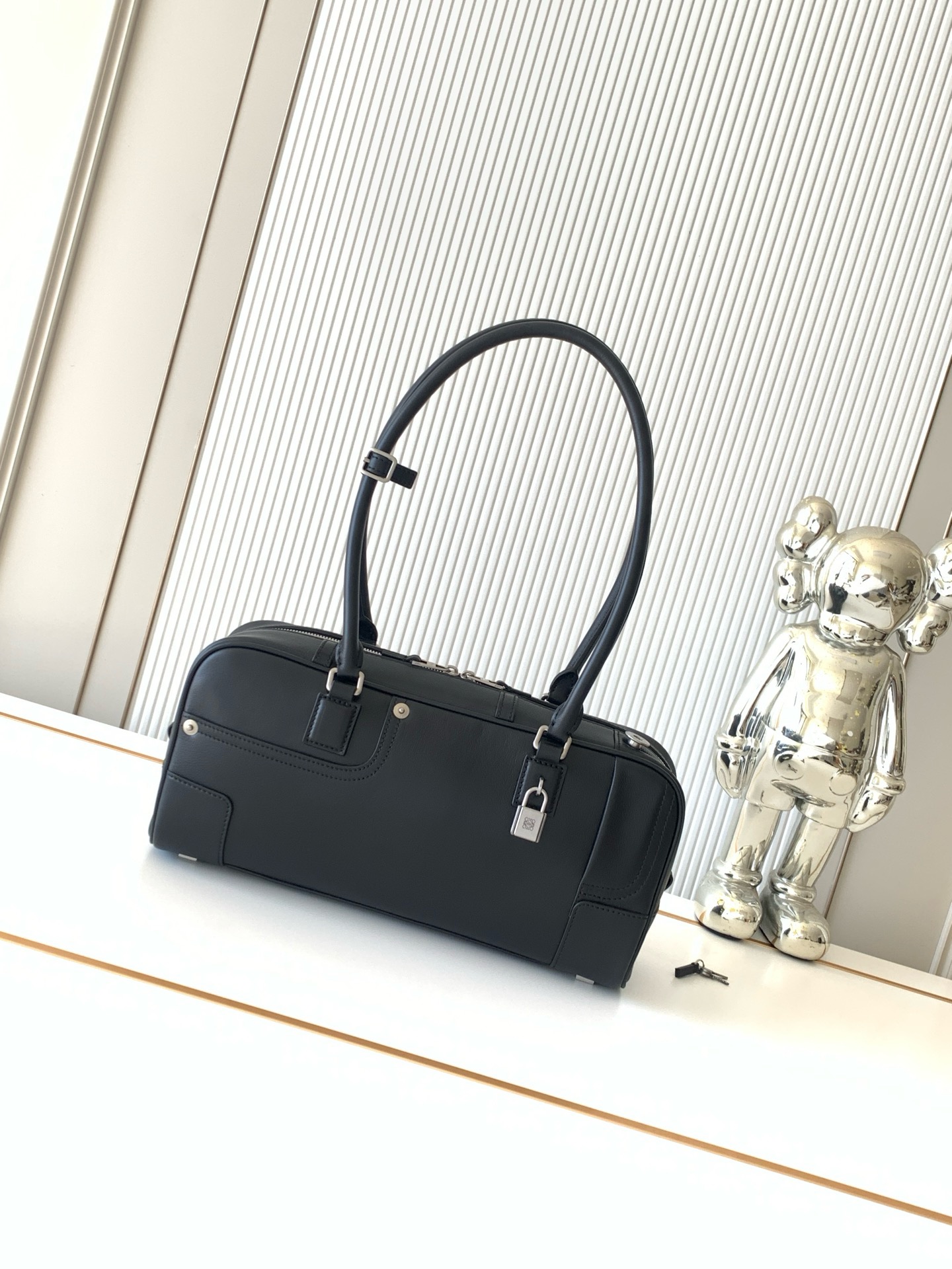 NO:854629,Panta Amazona 31 Cropped bag Amazona in glossy calfskin A classic shape with signature padlock This elongated Cropped version in glossy calfskin with a vintage finish Decorated with denim trouser-style details 'Can be worn as a shoulder or hand carry' Articulated handles with handle fastening 'Zip closure Calfskin zipper pull * One slip pocket * Bottom protected by metal feet ' Gold suede lining * Anagram embossing  Size 30.5CM~15CM~9CM Style number 9167 Color black, Loewe, loewe, cowhide19860909亮面牛皮革 Panta Amazona 31 Cropped手袋Amazona 呈现经典造型配有标志性挂锁此加长 Cropped版本采用复古饰面亮面牛皮革制成饰有单宁布长裤风格细节“可肩背或手提“铰接式提手搭配提手扣件“拉链开合牛皮革拉链头*一个插袋*包底以金属脚钉保护“金色绒面革衬里*Anagram 压纹 尺寸30.5CM~15CM~9CM 款号9167 颜色黑色,罗意威,loewe,cowhide,Bag