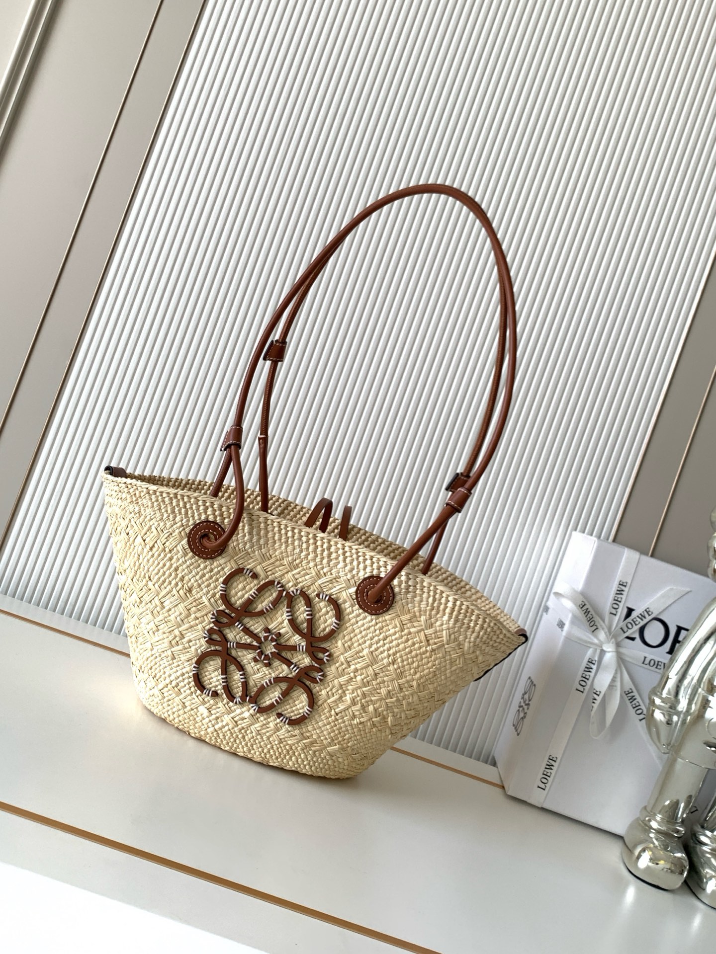 NO:854734,[Imported Original Raffia] Small Iraca Palm Fiber and Cow Leather Anagram Basket Handbags Super Stars of the Same Style A traditional basket handbag with a classic hand-woven body, tubular cow leather straps, and a cow leather Anagram embossed patch. This small version is made from the Iraca palm, which is harvested and sun-dried in Colombia, then guided by fair trade principles by Corporacion Oficio y Arte  Knitted by our artisan women, sizes may vary slightly due to handcrafting, making each purchase unique!  A must-have woven handbag in summer. If you want to choose a bag as a summer must-have, it must be a woven bag. It is suitable for daily wear and weekend outings. It directly brings the summer atmosphere. The Anagram Basket handbag has a classic hand-woven basket handbag. It is a holiday style when you carry it casually. ◇A must-have for summer. Size 34CM～16.5CM～13CM. Style No. 8031. Color brown [new version], Loewe, loewe, cowhide19860909【进口原厂拉菲草】小号伊拉卡棕榈纤维和牛皮革 Anagram Basket 手袋超多明星同款一个传统的篮子手袋带有经典的手工编织包身管状牛皮革带子,以及一块牛皮革 Anagram 压纹贴片这个小尺寸版本采用伊拉卡棕榈制成,这种棕榈树在哥伦比亚种植收获并晒干,然后由公平贸易原则指导的 Corporacion Oficio y Arte 组织的女工匠编织由于手工制作,尺寸可能略有不同,使每次购买都二！夏天必备编织手袋,如果要选一只包包作为夏日必备那一定是编织包.既适合日常穿搭,也适合周末外出,把夏日的氛围感直接拉满Anagram Basket手袋带有经典手工编织的篮子手袋.随手一背就是度假风◇夏日搭配必备 尺寸34CM～16.5CM～13CM 款号8031 颜色棕色【新版本】,罗意威,loewe,cowhide,Bag