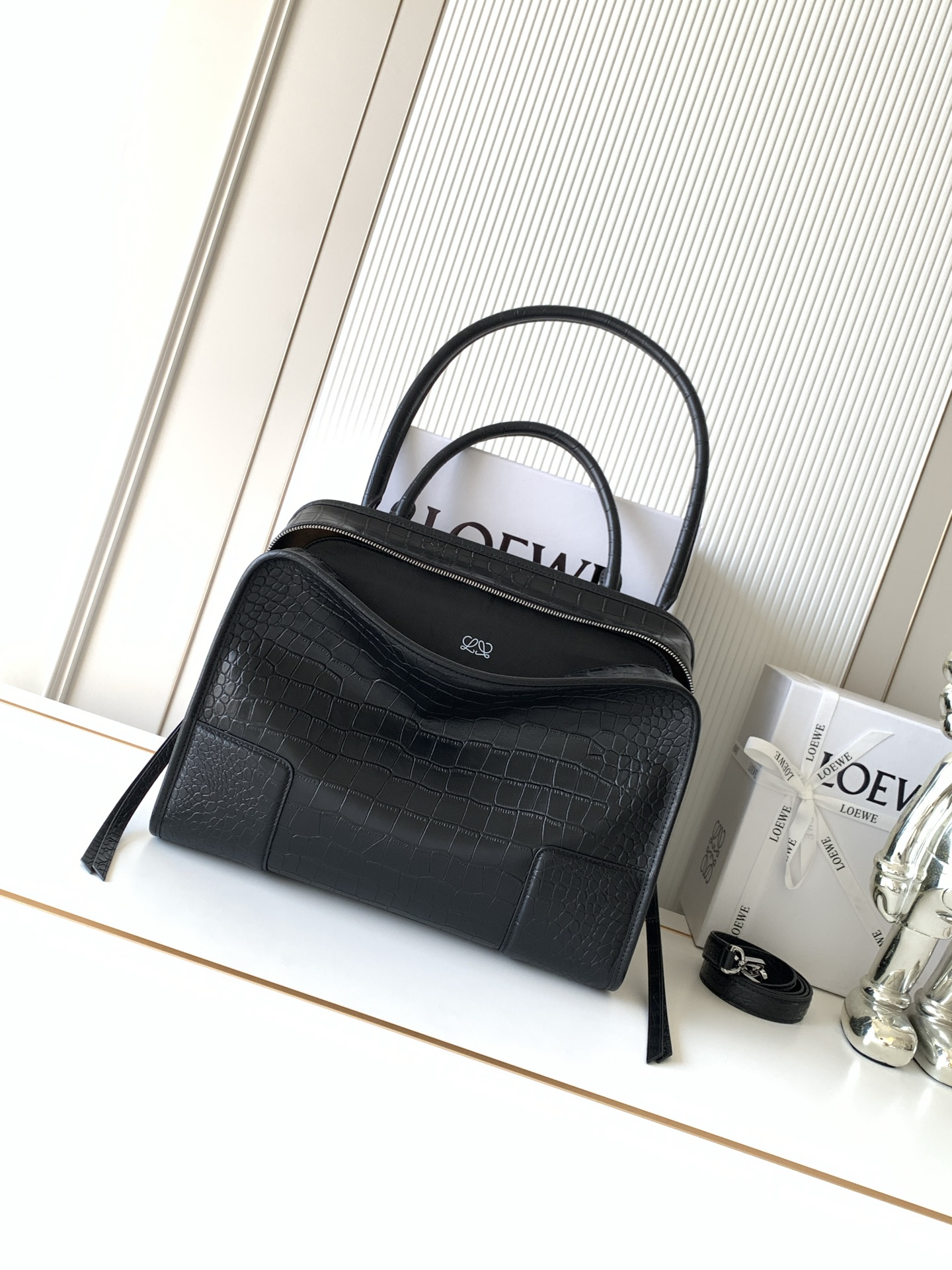 NO:854791,New large size soft cow leather Amazona 180 handbag, same style as Amazona stars  180 reinterprets the legendary handbag in a casual silhouette with a single top handle. The bag features an open design. The main compartment is secured with a hidden buckle and features a detachable shoulder and cross-body strap for a practical style. This large version is made from soft calfskin leather*3  Two ways to carry: Short handle, detachable shoulder and cross-body straps *Zipper with two leather zipper pulls*Two compartments, main compartment with magnetic closure  L embossed brand logo Size 34.5CM～27CM～14CM Style No. 9173 Color Crocodile pattern/black, Loewe, loewe, cowhide19860909新款大号柔软牛皮革 Amazona 180 手袋 明星同款Amazona 180重新诠释传奇手袋呈现休闲廓形,搭配单一顶部提手手袋采用开放式设计主隔层以隐藏扣固定搭配可拆卸肩背和斜挎背带打造实用风格.此大号版本采用柔软牛皮革制成*三种携带方式短提手、可拆卸肩背和斜挎背带*拉链配有两个皮革拉链头*两个隔层,主隔层以磁扣开合*内部扁平口袋*左侧D形环可定制*织物衬里*烫金或烫银,Double L 压纹品牌标志 尺寸34.5CM～27CM～14CM 款号9173 颜色鳄鱼纹/黑色,罗意威,loewe,cowhide,Bag