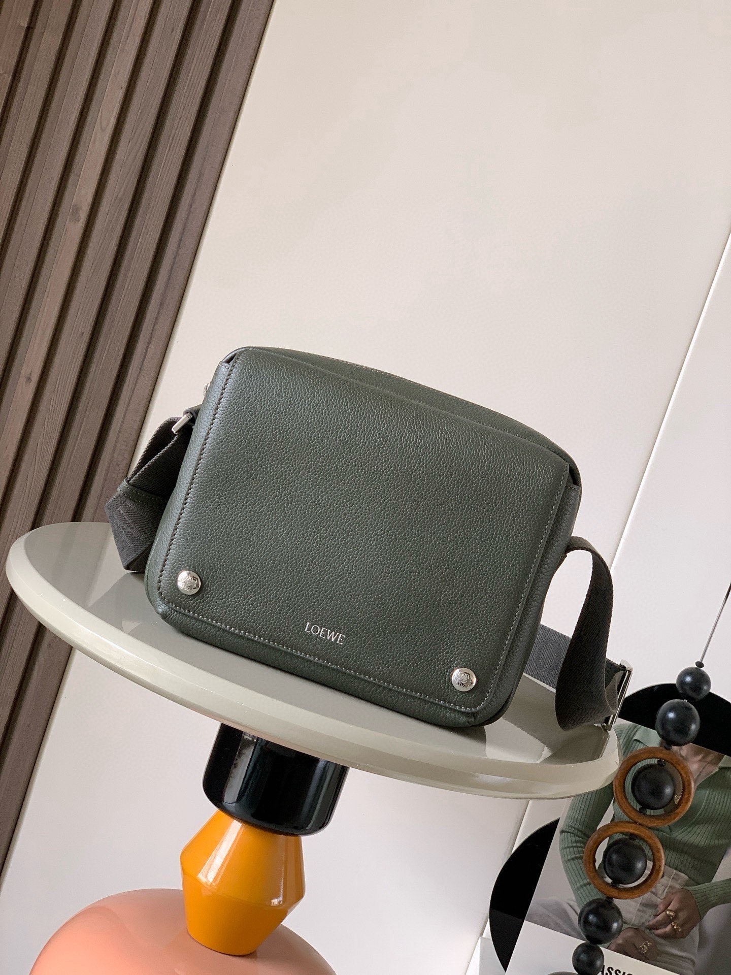NO:854826,The new small Pebble messenger bag in pebbled calf leather. The Pebble messenger bag adopts a practical and sophisticated design and is equipped with a double signature Anagram Pebble.  This medium version is made of soft grained cowhide leather * Adjustable LOEWE webbing * Zipper closure * One magnetic front pocket, one internal slip pocket * Suede lining * LOEWE hot silver, Anagram Pebble Size 23cm ~ 9cm ~ 18cm Style No. 9094 Color Dark Palm Olive Green, Loewe, loewe, loewe, cowhide19860909新款小号荔枝纹牛皮革 Pebble 邮差包Pebble 邮差包采用实用精巧设计,配有双重标志性 Anagram Pebble ．此中号版本采用柔软粒面牛皮革制成＊可调节LOEWE 织带＊拉链开合＊一个磁扣开合正面口袋,一个内部插袋＊绒面革衬里＊ LOEWE 烫银, Anagram Pebble 尺寸23cm～9cm~18cm 款号9094 颜色深棕榄绿,罗意威,loewe,loewe,cowhide,Bag