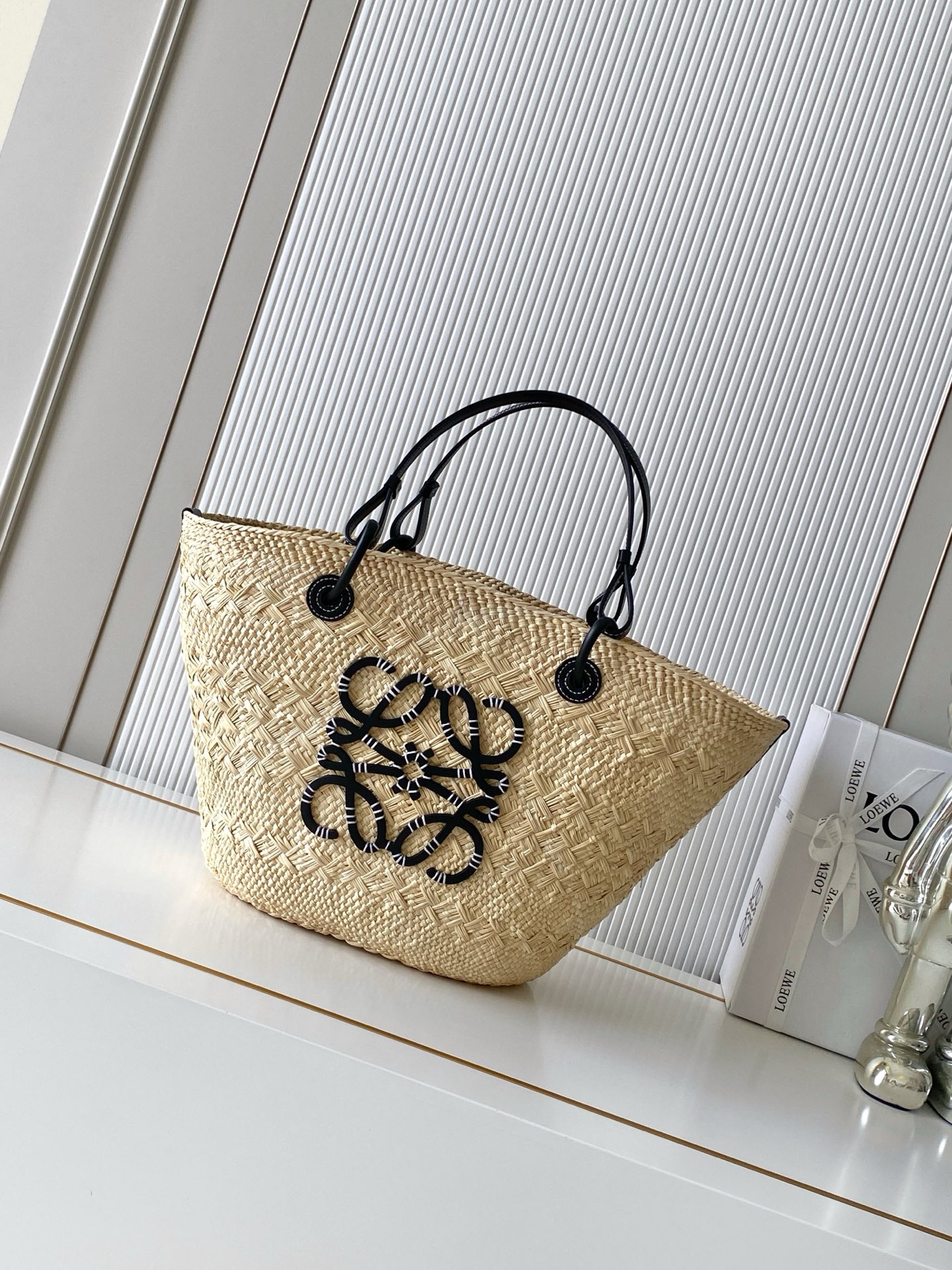 NO:880434,[New imported original raffia] Large Iraca Palm Fiber and Cow Leather Anagram Basket Handbag Super Many Stars The Same Style A traditional basket handbag with a classic hand-woven body, tubular cow leather straps, and a cow leather Anagram embossed patch. This small size version is made from Iraca Palm, a palm tree grown in Colombia that is harvested and sun-dried, then guided by fair trade principles by Corporacion Oficio y Arte  Knitted by our artisan women, sizes may vary slightly due to handcrafting, making each purchase unique!  A must-have woven handbag in summer. If you want to choose a bag as a summer must-have, it must be a woven bag. It is suitable for daily wear and weekend outings. It directly brings the summer atmosphere. The Anagram Basket handbag has a classic hand-woven basket handbag. It is a holiday style when you carry it casually. ◇A must-have for summer. Size 46CM～24CM～15CM. Style No. 8032. Color: black, Loewe, loewe, cowhide.19860909【新款进口原厂拉菲草】大号伊拉卡棕榈纤维和牛皮革 Anagram Basket 手袋超多明星同款一个传统的篮子手袋带有经典的手工编织包身管状牛皮革带子,以及一块牛皮革 Anagram 压纹贴片这个小尺寸版本采用伊拉卡棕榈制成,这种棕榈树在哥伦比亚种植收获并晒干,然后由公平贸易原则指导的 Corporacion Oficio y Arte 组织的女工匠编织由于手工制作,尺寸可能略有不同,使每次购买都二！夏天必备编织手袋,如果要选一只包包作为夏日必备那一定是编织包.既适合日常穿搭,也适合周末外出,把夏日的氛围感直接拉满Anagram Basket手袋带有经典手工编织的篮子手袋.随手一背就是度假风◇夏日搭配必备 尺寸46CM～24CM～15CM 款号8032 颜色黑色,罗意威,loewe,cowhide,Bag
