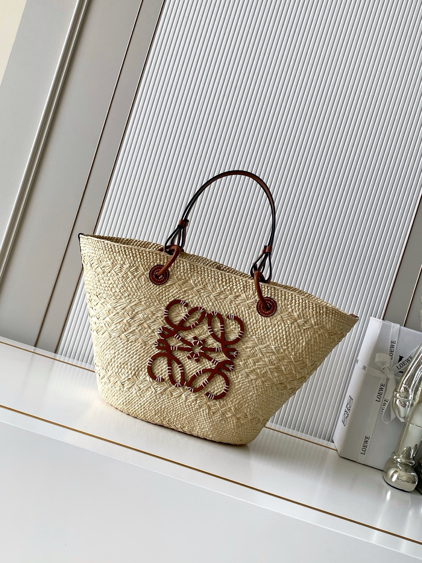 NO:880441,[New imported original raffia] Large Iraca Palm Fiber and Cow Leather Anagram Basket Handbag Super Many Stars The Same Style A traditional basket handbag with a classic hand-woven body, tubular cow leather straps, and a cow leather Anagram embossed patch. This small size version is made from Iraca Palm, a palm tree grown in Colombia that is harvested and sun-dried, then guided by fair trade principles by Corporacion Oficio y Arte  Knitted by our artisan women, sizes may vary slightly due to handcrafting, making each purchase unique!  A must-have woven handbag in summer. If you want to choose a bag as a summer must-have, it must be a woven bag. It is suitable for daily wear and weekend outings. It directly brings the summer atmosphere. The Anagram Basket handbag has a classic hand-woven basket handbag. It is a holiday style when you carry it casually. ◇A must-have for summer. Size 46CM～24CM～15CM. Style No. 8032. Color Brown, Loewe, loewe, cowhide19860909【新款进口原厂拉菲草】大号伊拉卡棕榈纤维和牛皮革 Anagram Basket 手袋超多明星同款一个传统的篮子手袋带有经典的手工编织包身管状牛皮革带子,以及一块牛皮革 Anagram 压纹贴片这个小尺寸版本采用伊拉卡棕榈制成,这种棕榈树在哥伦比亚种植收获并晒干,然后由公平贸易原则指导的 Corporacion Oficio y Arte 组织的女工匠编织由于手工制作,尺寸可能略有不同,使每次购买都二！夏天必备编织手袋,如果要选一只包包作为夏日必备那一定是编织包.既适合日常穿搭,也适合周末外出,把夏日的氛围感直接拉满Anagram Basket手袋带有经典手工编织的篮子手袋.随手一背就是度假风◇夏日搭配必备 尺寸46CM～24CM～15CM 款号8032 颜色棕色,罗意威,loewe,cowhide,Bag