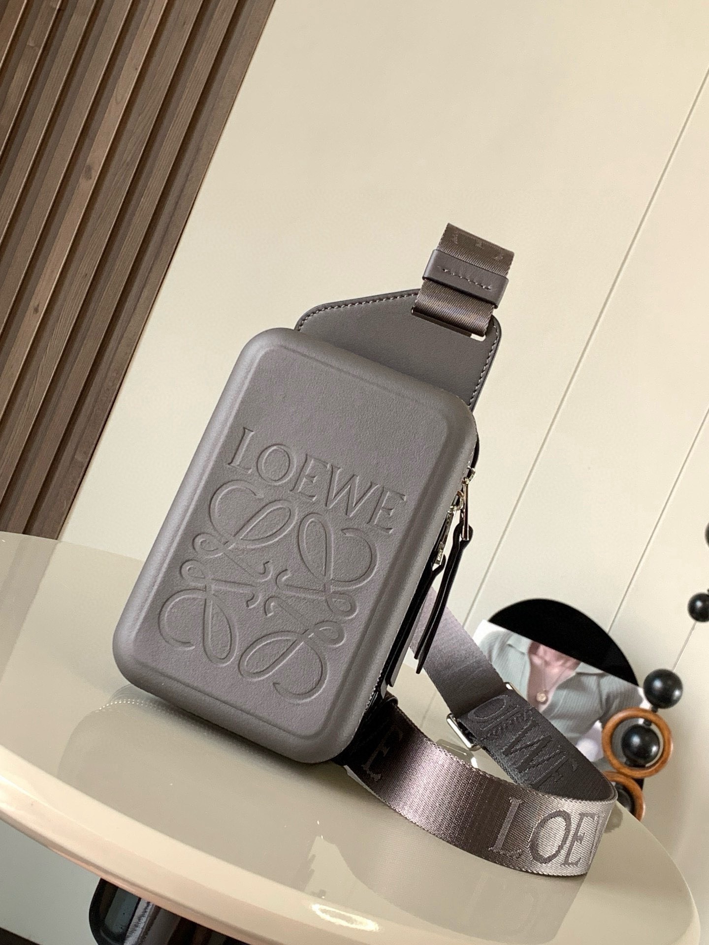 NO:880475,Smooth Cow Leather Molded Sling Handbag The Molded Sling is a practical crossbody bag with L0EWE webbing and a rotatable branded slider that allows the shoulder strap to fit to the body. This version is made of smooth cow leather* Can be worn crossbody* Zipper closure, cow leather zip puller* Two interior compartments* Cow leather lining* L0EWE Anagram embossed Size 18.5CM~12.5CM~6.5CM  Style number 9117 color dark gray/gray coffee, Loewe, loewe, satchels, crossbody bags, cowhide19860909光滑牛皮革 Molded Sling手袋Molded Sling是一款实用的斜挎包配有L0EWE织带和可旋转的品牌标记滑块使肩带能够贴合身体此版本采用光滑牛皮革制成* 可斜挎* 拉链开合,牛皮革拉链头* 两个内部隔层* 牛皮革衬里* L0EWE Anagram 压纹 尺寸18.5CM~12.5CM~6.5CM 款号9117 颜色深灰/灰咖,罗意威,loewe,satchels,crossbody bags,cowhide,Bag
