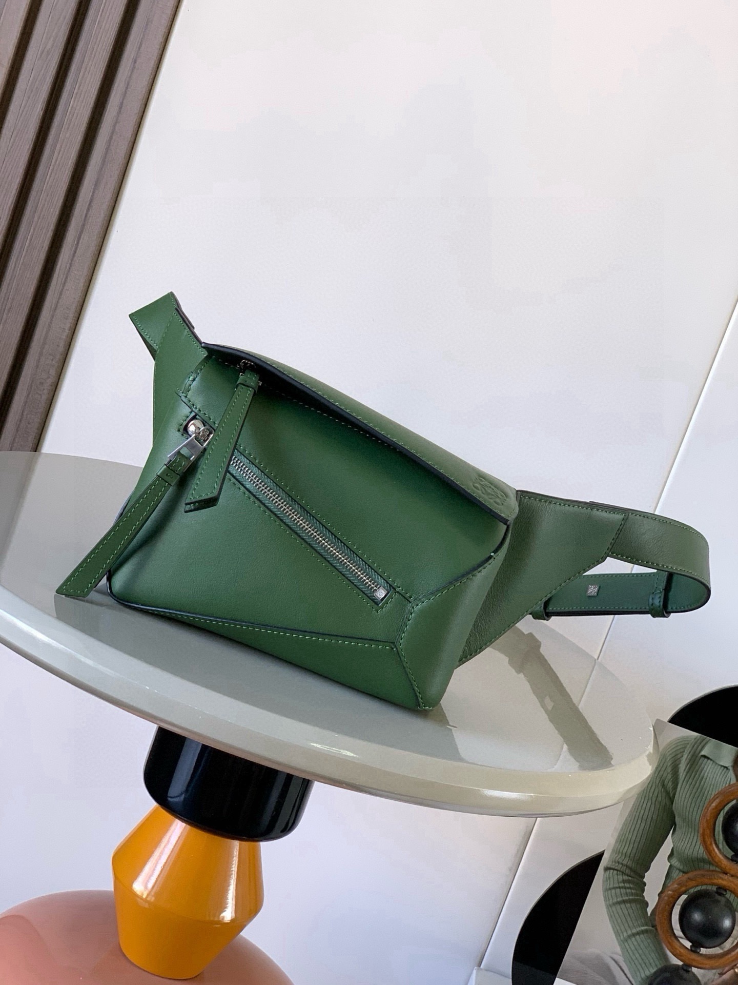 NO:880497,The new mini classic cow leather Puzzle waist bag has a rectangular shape and precise cutting technology to create Puzzle's unique geometric lines. This small mini waist bag is made of classic cow leather. The leather is soft and lightweight, and the shape is low-key and recognizable. It can be matched for business or leisure. Later, I found a puzzle waist bag, which is relatively classic and relatively niche for puzzle. This waist bag removes the handle of the classic puzzle and turns the classic puzzle  The rear zipper bag has been moved to the front belt and has become a non-detachable latch buckle wide belt. In addition to retaining the classic puzzle casual and literary basic bag shape, the fork adds a cool mechanical feel. It is also classic and versatile. It has a considerable capacity and a better upper body proportion. Shoulder or cross-body, adjustable shoulder strap, equipped with metal buckle opening and closing. Size 18CM～12CM～7.5CM. Style No. 9115. Color green plain weave, Loewe, loewe, cowhide.19860909新款迷你号经典牛皮革 Puzzle 腰包长方体形状和精确的切割技术创造了Puzzle 独特的几何线条这款小迷你号腰包采用经典牛皮革制成皮质柔软轻便,造型低调有辨识度不管是商务还是休闲都可以搭配后来叉发现一款 puzzle腰包,相对经典,puzzle 来说比较小众此款腰包去掉了经典puzzle的手柄把经典puzzle 后面的后置拉链袋移到了前面腰带也变成不可拆卸插销扣宽腰带保留经典puzzle随性文艺的基本包型外,叉增加了一份酷酷的机械感同样经典百搭不仅容量可观而且上身比例更好.肩背或斜挎 ,可调节肩带,配有金属搭扣开合 尺寸18CM～12CM～7.5CM 款号9115 颜色绿色平纹,罗意威,loewe,cowhide,Bag