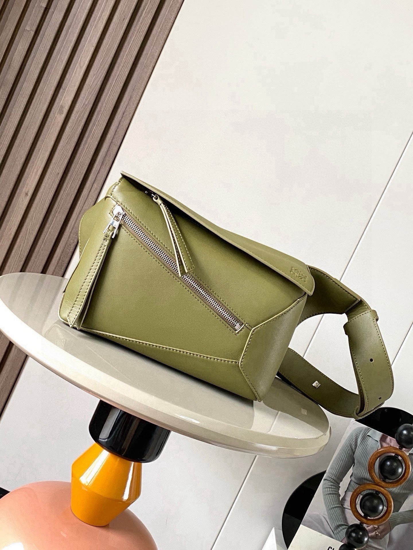 NO:880476,The new small classic cow leather Puzzle waist bag has a rectangular shape and precise cutting technology to create Puzzle's unique geometric lines. This small waist bag is made of classic cow leather. The leather is soft and lightweight, and the shape is low-key and recognizable. It can be worn with the back, whether it is business or leisure. I found a puzzle waist bag, which is relatively classic and puzzle is relatively niche. This waist bag removes the handle of the classic puzzle and puts the classic puzzle  The rear zipper bag has been moved to the front belt and has become a non-detachable latch buckle wide belt. In addition to retaining the classic puzzle casual and literary basic bag shape, the fork adds a cool mechanical feel and is also classic and versatile. It not only has considerable capacity but also has a better upper body proportion. Shoulder or crossbody, adjustable shoulder strap, equipped with metal buckle closure. Size 24CM～16CM～10.5CM. Style No. 9114. Color: olive, Loewe, loewe, cowhide.19860909新款小号经典牛皮革 Puzzle 腰包长方体形状和精确的切割技术创造了Puzzle 独特的几何线条这款小号腰包采用经典牛皮革制成皮质柔软轻便,造型低调有辨识度不管是商务还是休闲都可以搭配后来叉发现一款 puzzle腰包,相对经典,puzzle 来说比较小众此款腰包去掉了经典puzzle的手柄把经典puzzle 后面的后置拉链袋移到了前面腰带也变成不可拆卸插销扣宽腰带保留经典puzzle随性文艺的基本包型外,叉增加了一份酷酷的机械感同样经典百搭 不仅容量可观而且上身比例更好.肩背或斜挎 ,可调节肩带,配有金属搭扣开合 尺寸24CM～16CM～10.5CM 款号9114 颜色橄榄色,罗意威,loewe,cowhide,Bag