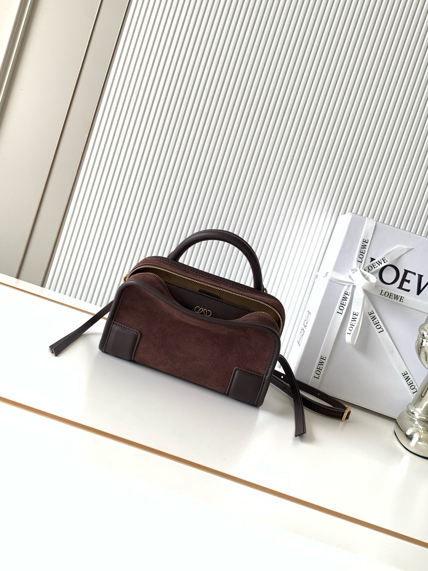 NO:895161,New Mini Suede Amazona 180 Handbag Celebrity Same Style Amazona  180 reinterprets the legendary bag in a casual silhouette with a single top handle. The bag features an open main compartment with a hidden buckle and a detachable shoulder and cross-body strap for a practical style. This mini version is made from soft calf leather*  Three ways to carry Short handle, detachable shoulder and cross-body strap *Zipper with two leather zipper pulls*Two compartments, main compartment with magnetic closure  L embossed brand logo, size 20CM～11.5CM～7CM, style number 9175, color dark maroon/light maroon matte, Loewe, loewe, cowhide19860909新款迷你号绒面革 Amazona 180 手袋 明星同款Amazona 180重新诠释传奇手袋呈现休闲廓形,搭配单一顶部提手手袋采用开放式设计主隔层以隐藏扣固定搭配可拆卸肩背和斜挎背带打造实用风格.此迷你号版本采用柔软牛皮革制成*三种携带方式短提手、可拆卸肩背和斜挎背带*拉链配有两个皮革拉链头*两个隔层,主隔层以磁扣开合*内部扁平口袋*左侧D形环可定制*织物衬里*烫金或烫银,Double L 压纹品牌标志 尺寸20CM～11.5CM～7CM 款号9175 颜色深栗色/浅栗色磨砂,罗意威,loewe,cowhide,Bag