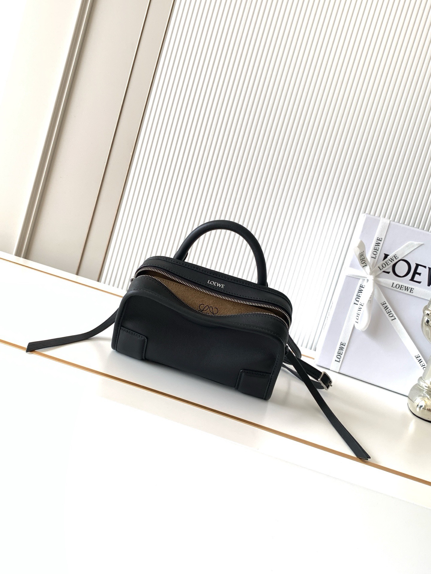 NO:895177,New mini soft calf leather Amazona 180 handbag, same style as Amazona stars  180 reinterprets the legendary bag in a casual silhouette with a single top handle. The bag features an open main compartment with a hidden buckle and a detachable shoulder and cross-body strap for a practical style. This mini version is made from soft calf leather*  Three ways to carry Short handle, detachable shoulder and cross-body strap *Zipper with two leather zipper pulls*Two compartments, main compartment with magnetic closure  L embossed brand logo Size 20CM～11.5CM～7CM Style number 9175 Color black, Loewe, loewe, cowhide19860909新款迷你号柔软牛皮革 Amazona 180 手袋 明星同款Amazona 180重新诠释传奇手袋呈现休闲廓形,搭配单一顶部提手手袋采用开放式设计主隔层以隐藏扣固定搭配可拆卸肩背和斜挎背带打造实用风格.此迷你号版本采用柔软牛皮革制成*三种携带方式短提手、可拆卸肩背和斜挎背带*拉链配有两个皮革拉链头*两个隔层,主隔层以磁扣开合*内部扁平口袋*左侧D形环可定制*织物衬里*烫金或烫银,Double L 压纹品牌标志 尺寸20CM～11.5CM～7CM 款号9175 颜色黑色,罗意威,loewe,cowhide,Bag