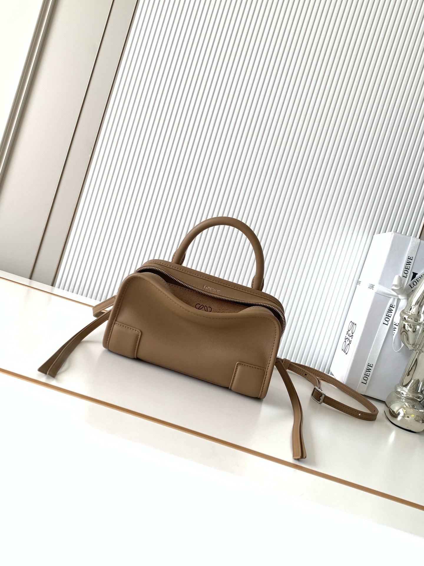 NO:895188,New mini soft calf leather Amazona 180 handbag, same style as Amazona stars  180 reinterprets the legendary bag in a casual silhouette with a single top handle. The bag features an open main compartment with a hidden buckle and a detachable shoulder and cross-body strap for a practical style. This mini version is made from soft calf leather*  Three ways to carry Short handle, detachable shoulder and cross-body strap *Zipper with two leather zipper pulls*Two compartments, main compartment with magnetic closure  L embossed brand logo Size 20CM～11.5CM～7CM Style No. 9175 Color Mocha, Loewe, loewe, cowhide19860909新款迷你号柔软牛皮革 Amazona 180 手袋 明星同款Amazona 180重新诠释传奇手袋呈现休闲廓形,搭配单一顶部提手手袋采用开放式设计主隔层以隐藏扣固定搭配可拆卸肩背和斜挎背带打造实用风格.此迷你号版本采用柔软牛皮革制成*三种携带方式短提手、可拆卸肩背和斜挎背带*拉链配有两个皮革拉链头*两个隔层,主隔层以磁扣开合*内部扁平口袋*左侧D形环可定制*织物衬里*烫金或烫银,Double L 压纹品牌标志 尺寸20CM～11.5CM～7CM 款号9175 颜色摩卡色,罗意威,loewe,cowhide,Bag