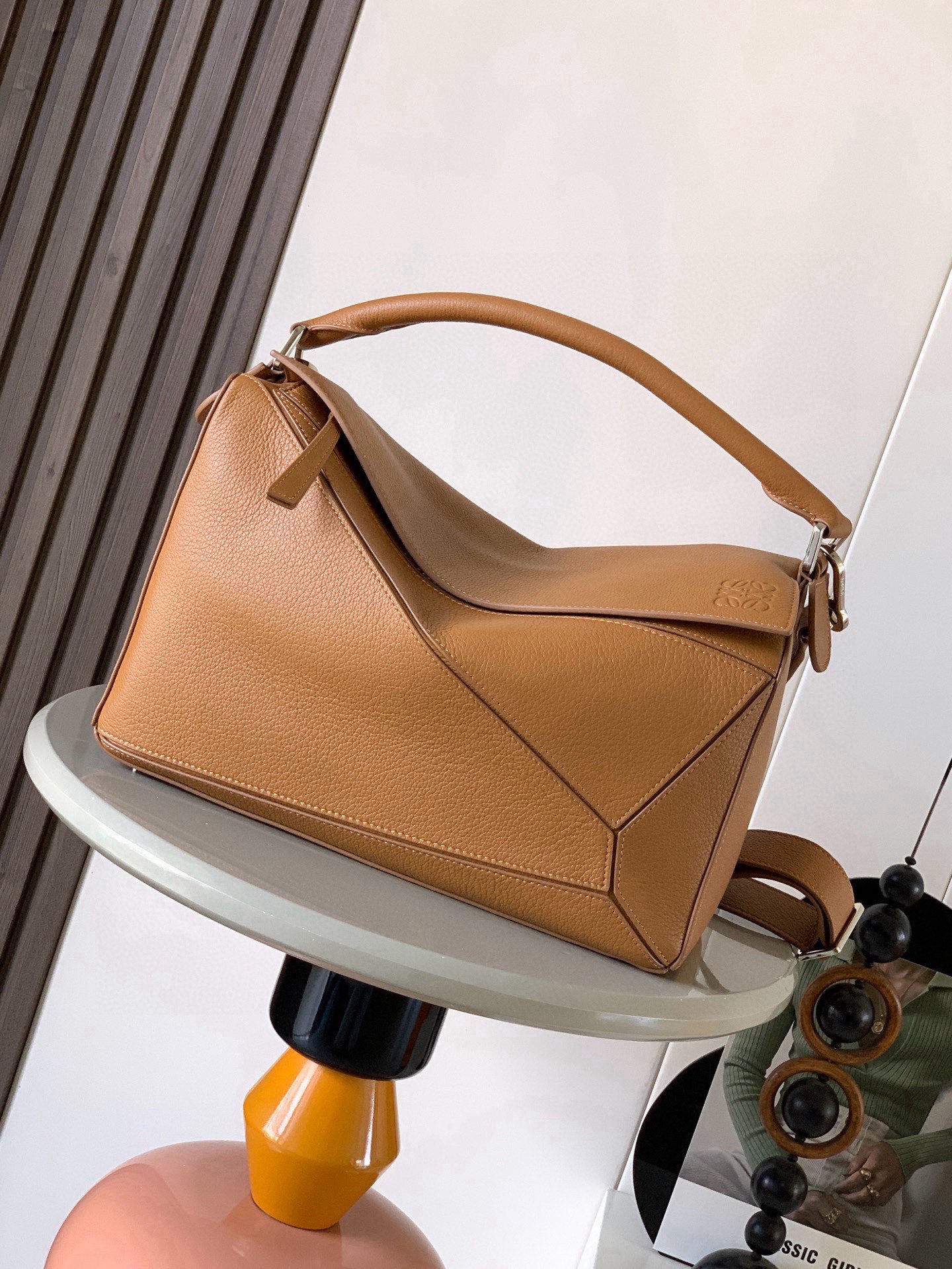 NO:895237,The new Puzzle size handbag Puzzle handbag is the creative director of Jonathan.  The first handbag launched by Jonathan Anderson, the cuboid shape and precise cutting techniques create the unique geometric lines of the Puzzle. This version is made from glossy cow leather with overlapping edges. * Can be worn on the shoulder, cross-body or handheld.  Anagram embossing meets the needs of different occasions. Unisex. Size 33cm～14.7cm～21.5cm. Style No. 9095. Color: light brown/deerskin, Loewe, loewe, cowhide.19860909新款Puzzle尺寸手袋Puzzle 手袋是创意总监乔纳森．安德森（ Jonathan Anderson）推出的首款手提包长方体形状和精确的切割技术创造了 Puzzle 独特的几何线条此版本采用亮面牛皮革制成饰有重叠边缘＊可肩背、斜挎或手提＊可拆卸可调节肩带＊外部后方拉链袋和两个内部插袋＊拉链开合牛皮革拉链头＊可以使用肩带和个性化挂饰进行定制＊绒面革衬里＊ Anagram 压纹 满足不同场合需求男女通用 尺寸33cm～14.7cm～21.5cm 款号9095 颜色浅棕色/鹿皮,罗意威,loewe,cowhide,Bag