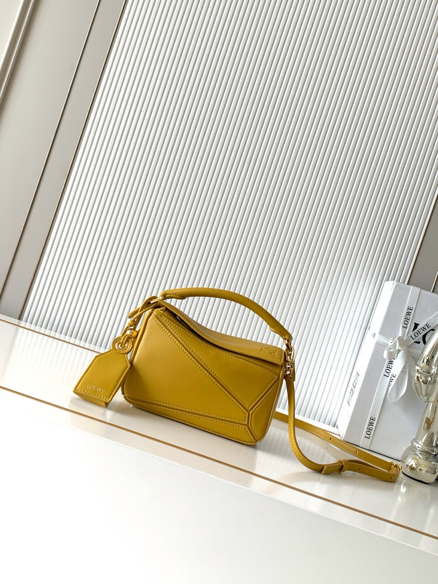 NO:895277,New version of the Geometric Bag Small Nappa Lamb Leather Featherlight Puzzle Bag,  The original imported Napa calfskin outlines a cuboid shape with unique geometric lines. The soft and lightweight Napa leather injects a casual and lazy style into the handbag. *Can be carried on the shoulder, crossbody or handheld*Detachable and adjustable shoulder strap, decorated with rotating buckle*Zipper  Closure, articulated zipper pull * One external zipped back pocket, one internal slip pocket * Removable, with secret pocket and balloon dice * Rectangular metal feet * This smaller version is made from soft Nappa calf leather * Small Puzzle  Can hold, for example, a large wallet, all sizes of mobile phones and sunglasses. Can be carried diagonally, over the shoulder, in the hand or by the top handle19860909新版本几何包小号纳帕羊皮革 Featherlight Puzzle 手袋, 原厂进口纳帕小牛皮以别具一格的几何线条勾勒长方体造型.柔软轻盈的纳帕皮革为手袋注入随性慵懒的风格.*可肩背、斜挎或手提*可拆卸可调节肩带,饰有旋转卡扣*拉链开合,铰接式拉链头*一个外部拉链后袋,一个内部插袋*可拆卸,饰有隐秘口袋和气球骰子*长方形金属脚钉*这个小尺寸版本采用柔软纳帕小牛皮革制成＊小号Puzzle 可以容纳例如一只大号钱包所有尺寸的手机和太阳镜斜、肩背、手拿或顶部提手携带＊可拆卸 款号9096 颜色芥末黄 尺寸24CM～16CM～10CM,罗意威,loewe,wallets,cowhide,sheepskin,Bag