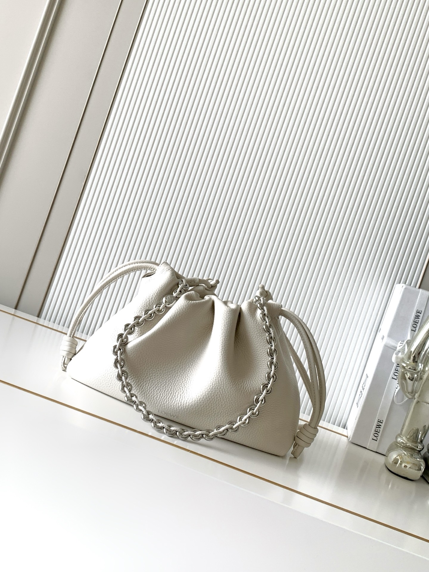 NO:895281,The new medium flamenco purse clutch in deer leather stars the same Flamenco Purse. It has a pleated design and signature knots on the side. This medium version is made of deer leather * Can be worn on the shoulder, cross-body or handbag * Detachable and adjustable leather shoulder strap * Detachable donut chain decorated with Anagram Pebble  ＊Ultra-light, super-soft and scratch-resistant, it comes with two shoulder straps and can be worn on one shoulder or cross-body. Magnetic buckle closure ＊Suede lining* LOEWE hot silver Size 30cm～10.5cm～20cm Style number 9057 Color Large white/deerskin, Loewe, loewe, loewe, handbag19860909新款中号鹿皮革 Flamenco Purse 手拿包明星同款Flamenco Purse 采用褶皱设计,侧面搭配标志性绳结此中号版本采用鹿皮革制成＊可肩背、斜挎或手提＊可拆卸可调节皮革肩带＊可拆卸甜甜圈链条饰有Anagram Pebble ＊超轻超软耐划痕,随意搭配自带两个肩带,单肩斜背都可以.磁扣开合＊绒面革衬里* LOEWE 烫银 尺寸30cm～10.5cm～20cm 款号9057 颜色大白色/鹿皮,罗意威,loewe,loewe,handbag,Bag