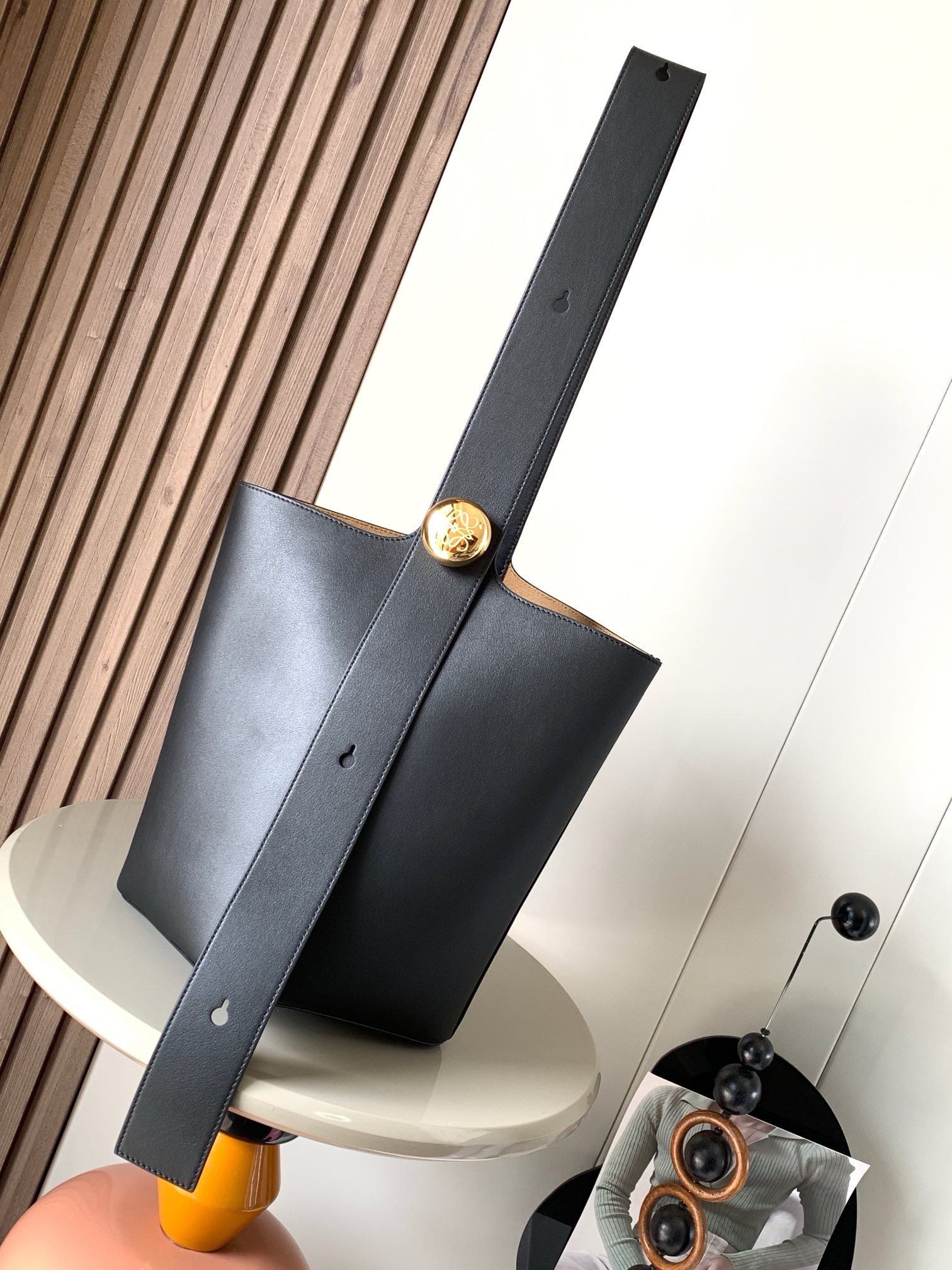 NO:895331,The medium-sized soft cow leather Pebble Bucket bucket bag is another representative of L0EWE's minimalism. The bucket bag is fashionable and simple, and can be equipped with Anagram golden pebble accessories. The finishing touch is that one of the characteristics of this bag is that the shoulder strap is very wide, so it is more suitable for cross-body wear or like the male models on the show, carrying the bag alone on the back to show ease. Of course, the wide shoulder strap is a double-door style. The one-shoulder carrying method is stable and neat, Pebble  A unique blend of pure, simple lines and eye-catching design flair creates a distinctive and innovative bag design. Iconic Anagram engraved hardware is both decorative and functional. Adjustable shoulder strap for multiple carry styles. Unique twist construction complements subtle details. This medium version is crafted from soft calfskin. *Can be worn over the shoulder or cross-body*Adjustable shoulder strap  Size 28CM~24CM~23CM Style No. 9045, Loewe, loewe, cowhide19860909中号柔软牛皮革 Pebble Bucket 水桶包是L0EWE极简主义的又一代表水桶包时尚简约且能装Anagram金色鹅卵石配件是点睛之笔这个包的一个特点是肩带很宽所以它更适合斜挎或者像秀场男模特那样,把包单拎在后背尽显自在,当然,宽肩带是双开门的穿搭福利单肩背法稳重利落,Pebble 将纯粹的简约线条与瞩目设计风格巧妙融合造就别具一格的创新的手袋设计标志性的 Anagram 雕刻五金件兼具装饰和实用功能可调节肩带长度并适合多种携带方式独特的扭曲结构与微妙的细节相得益彰此中号版本采用柔软牛皮革制成.*可肩背或斜挎*可调节肩带*磁扣开合*内袋“合成革衬里 *Anagram 雕刻卵石 尺寸28CM~24CM~23CM 款号9045,罗意威,loewe,cowhide,Bag