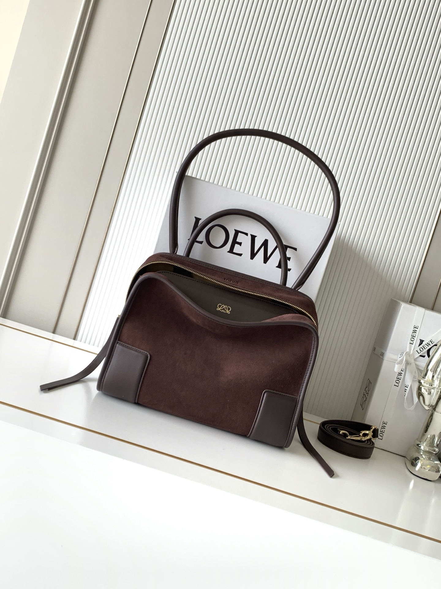 NO:895321,New medium-sized soft cow leather Amazona 180 handbag, the same style as Amazona stars  180 reinterprets the legendary handbag in a casual silhouette with a single top handle. The bag features an open design. The main compartment is secured with a hidden buckle and features a detachable shoulder and cross-body strap for a practical style. This medium version is made from soft calfskin leather*3  Two ways to carry: Short handle, detachable shoulder and cross-body straps *Zipper with two leather zipper pulls*Two compartments, main compartment with magnetic closure  L embossed brand logo Size 28CM～22.5CM～11CM Style number 9182 Color dark maroon matte, Loewe, loewe, cowhide19860909新款中号柔软牛皮革 Amazona 180 手袋 明星同款Amazona 180重新诠释传奇手袋呈现休闲廓形,搭配单一顶部提手手袋采用开放式设计主隔层以隐藏扣固定搭配可拆卸肩背和斜挎背带打造实用风格.此中号版本采用柔软牛皮革制成*三种携带方式短提手、可拆卸肩背和斜挎背带*拉链配有两个皮革拉链头*两个隔层,主隔层以磁扣开合*内部扁平口袋*左侧D形环可定制*织物衬里*烫金或烫银,Double L 压纹品牌标志 尺寸28CM～22.5CM～11CM 款号9182 颜色深栗色磨砂,罗意威,loewe,cowhide,Bag