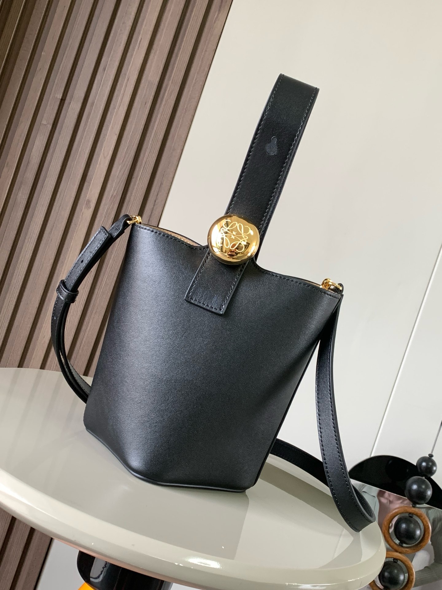 NO:895344,Mini soft grained calfskin Pebble Bucket Pebble cleverly combines pure simple lines with eye-catching design style to create a unique and innovative handbag design. Iconic Anagram  Engraved hardware is both decorative and functional, with an adjustable shoulder strap for multiple carry styles, with a unique twist complemented by subtle details. This mini version is crafted from soft grained calf leather. Can be worn cross-body, over the shoulder or by hand *Adjustable and removable shoulder strap *Magnetic closure *Inside pocket *Synthetic leather lining* Anagram Engraved Pebbles Style No. 9047 Color Black Plain  Size 20CM～16CM～16CM, Loewe, loewe, cowhide19860909迷你柔软粒面牛皮革 Pebble Bucket 水桶手袋Pebble将纯粹的简约线条与瞩目设计风格巧妙融合造就别具一格的创新的手袋设计.标志性的 Anagram 雕刻五金件兼具装饰和实用功能,可调节肩带长度并适合多种携带方式,独特的扭曲结构与微妙的细节相得益彰.此迷你版本采用柔软粒面牛皮革制成.可斜挎、肩背或手提＊可调节可拆卸肩带＊磁扣开合＊内袋＊合成革衬里* Anagram 雕刻卵石 款号9047 颜色黑色平纹 尺寸20CM～16CM～16CM,罗意威,loewe,cowhide,Bag