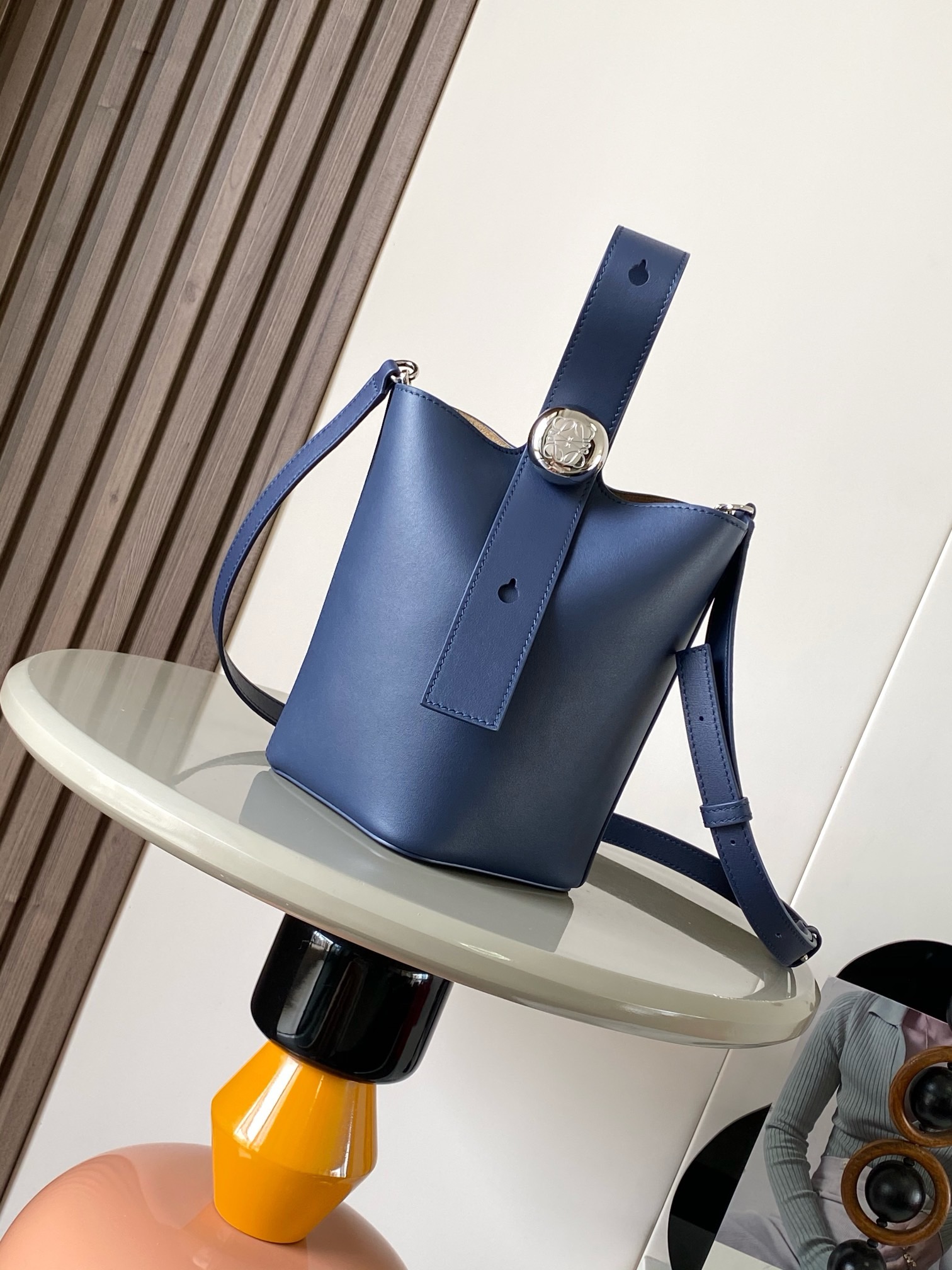 NO:895327,Mini Soft Grained Calf Leather Pebble Bucket Pebble cleverly combines pure simple lines with eye-catching design style to create a unique and innovative handbag design. Iconic Anagram  Engraved hardware is both decorative and practical, adjustable strap length and adaptable to a variety of carry styles, unique twist structure complemented by subtle details This mini version is crafted from soft grained calfskin. Can be worn cross-body, over the shoulder or by hand *Adjustable and removable shoulder strap *Magnetic closure *Inner pocket *Synthetic leather lining  Size 20CM～16CM～16CM, Loewe, loewe, cowhide19860909迷你柔软粒面牛皮革 Pebble Bucket 水桶手袋Pebble将纯粹的简约线条与瞩目设计风格巧妙融合造就别具一格的创新的手袋设计标志性的 Anagram 雕刻五金件兼具装饰和实用功能,可调节肩带长度并适合多种携带方式,独特的扭曲结构与微妙的细节相得益彰此迷你版本采用柔软粒面牛皮革制成.可斜挎、肩背或手提＊可调节可拆卸肩带＊磁扣开合＊内袋＊合成革衬里* Anagram 雕刻卵石 款号9047 颜色海军蓝 尺寸20CM～16CM～16CM,罗意威,loewe,cowhide,Bag