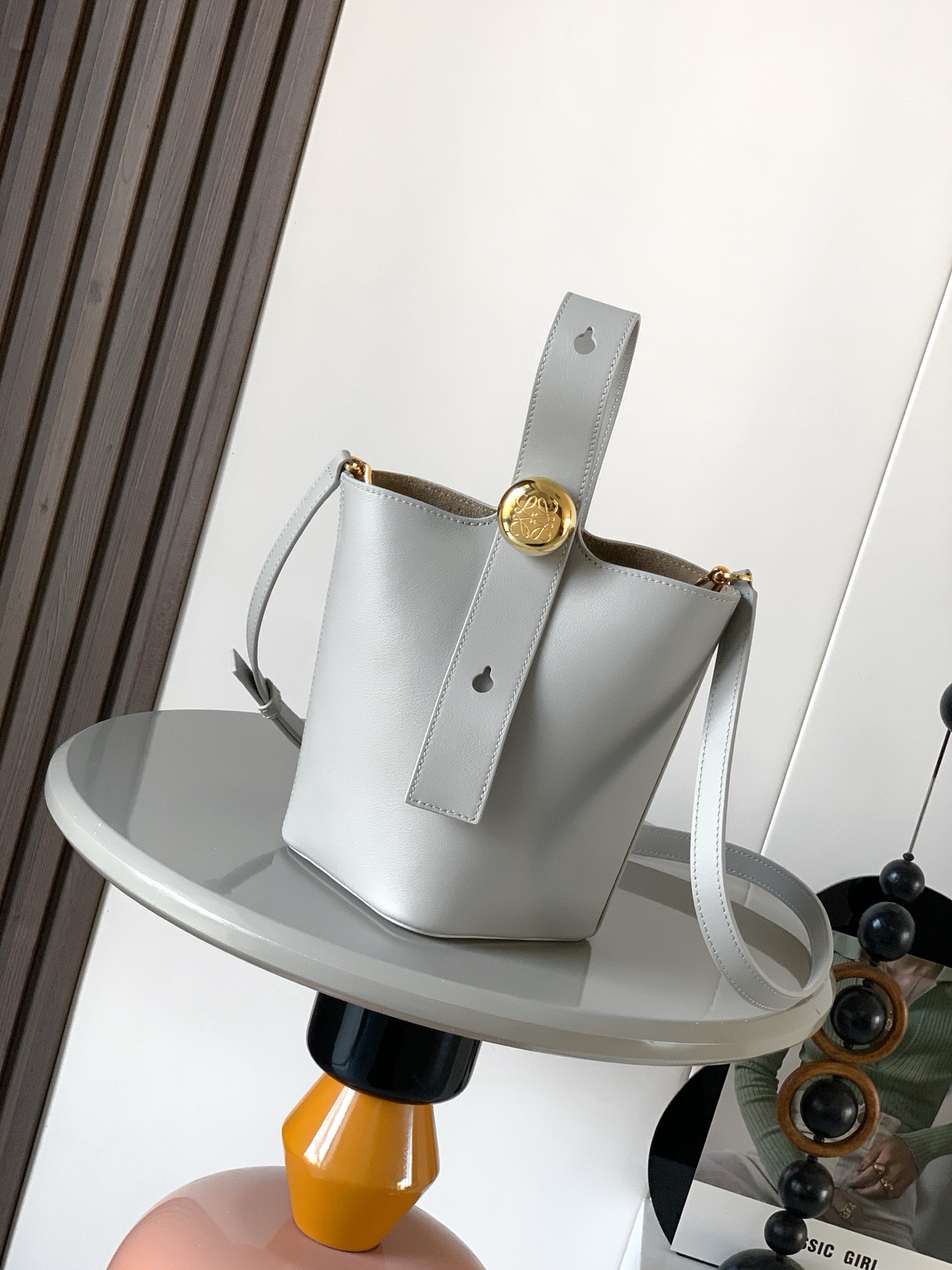 NO:895354,Mini soft grained calfskin Pebble Bucket Pebble cleverly combines pure simple lines with eye-catching design style to create a unique and innovative handbag design. Iconic Anagram  Engraved hardware is both decorative and practical, with an adjustable shoulder strap for multiple carry styles. The unique twist structure complements subtle details. This mini version is crafted from soft grained cowhide. Can be worn cross-body, over the shoulder or by hand * Adjustable and removable shoulder strap * Magnetic closure * Internal pocket * Synthetic leather lining * Anagram Engraved Pebbles Style No. 9047 Color Silver  Size 20CM～16CM～16CM, Loewe, loewe, cowhide19860909迷你柔软粒面牛皮革 Pebble Bucket 水桶手袋Pebble将纯粹的简约线条与瞩目设计风格巧妙融合造就别具一格的创新的手袋设计.标志性的 Anagram 雕刻五金件兼具装饰和实用功能,可调节肩带长度并适合多种携带方式,独特的扭曲结构与微妙的细节相得益彰.此迷你版本采用柔软粒面牛皮革制成.可斜挎、肩背或手提＊可调节可拆卸肩带＊磁扣开合＊内袋＊合成革衬里* Anagram 雕刻卵石 款号9047 颜色银灰色 尺寸20CM～16CM～16CM,罗意威,loewe,cowhide,Bag