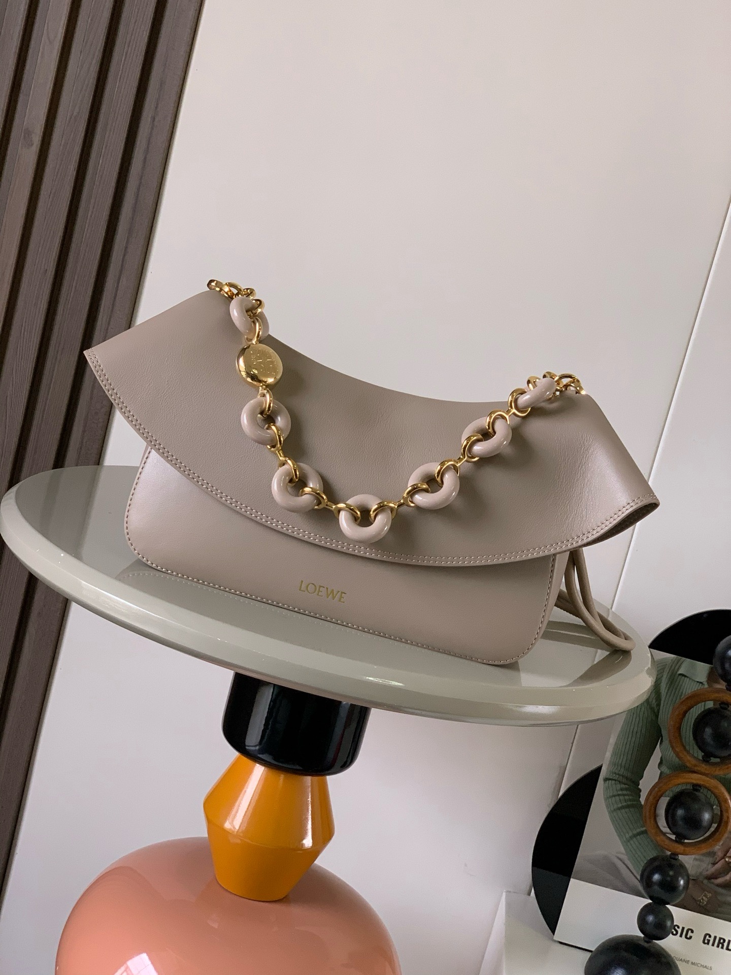 NO:895350,Medium Smooth Cow Leather Ola Handbag Ola is a soft, lightweight, flexible and versatile summer handbag with a curved body, a smooth-line flap and a striking donut chain. This medium version is made of smooth cow leather * Detachable cow leather tubular shoulder strap Detachable donut chain * Flap closure * One inner pocket L0EWE Hot stamping, engraved Anagram logo Size 26CM ~ 18CM ~ 13CM Style No. 9150  Color sandy,loewe,loewe,cowhide19860909中号光滑牛皮革 Ola 手袋Ola 是柔软轻便且灵活百搭的夏日手袋采用弧形主体、线条流畅的翻盖和醒目甜甜圈链条此中号版本采用光滑牛皮革制成*可拆卸牛皮革管状肩带可拆卸甜甜圈链条*翻盖开合*一个内袋 L0EWE 烫金,镌刻 Anagram 标志 尺寸26CM～18CM～13CM 款号9150 颜色沙色,罗意威,loewe,cowhide,Bag