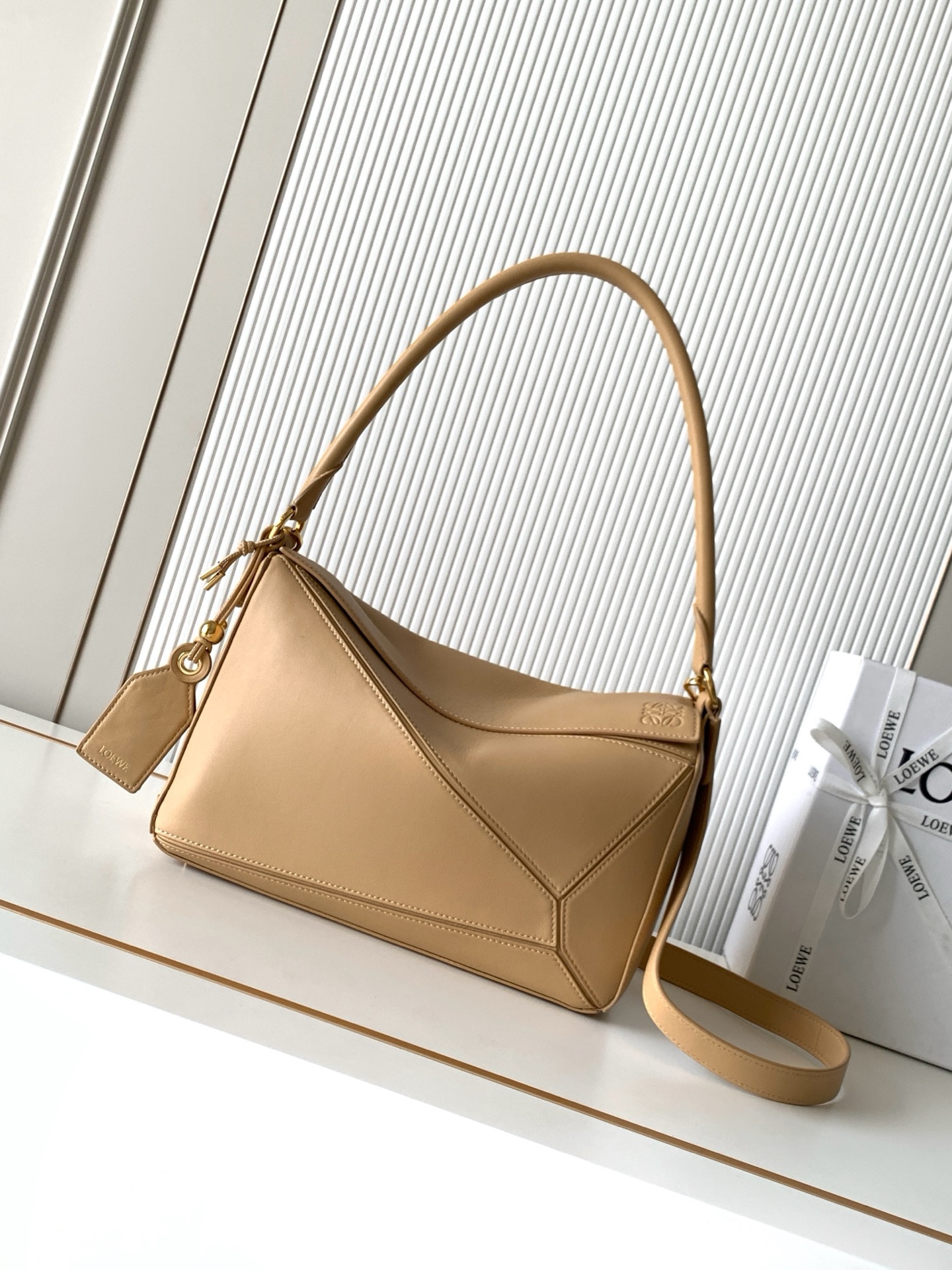 NO:895378,New Geometric Bag Medium Nappa Sheep Leather Featherlight Puzzle Handbag Featherlight Puzzle Unique geometric lines outline the rectangular shape. Soft and lightweight Nappa leather injects a casual and lazy style into the handbag. This version comes with a shoulder strap, which injects new vitality into the design. *Can be worn on the shoulder or cross-body. Embossed, engraved words inside the plaque Size 29CM～19.5CM～12CM Style number 9177 Color beige, Loewe, loewe, sheepskin19860909新款几何包中号納帕羊皮革 Featherlight Puzzle 手袋Featherlight Puzzle 以别具一格的几何线条勾勒长方体造型柔软轻盈的纳帕皮革为手袋注入随性慵懒的风格此版本配备肩带,为设计注入崭新活力*可肩背或斜挎*可拆卸可调节肩带饰有旋转卡扣“拉链开合,铰接式拉链头*可拆卸烫金或烫银标签饰有隐秘口袋和气球骰子*长方形金属脚钉*纳帕羊皮革衬里*Anagram 压纹、饰牌内部镌刻字样 尺寸29CM～19.5CM～12CM 款号9177 颜色米黄色,罗意威,loewe,sheepskin,Bag