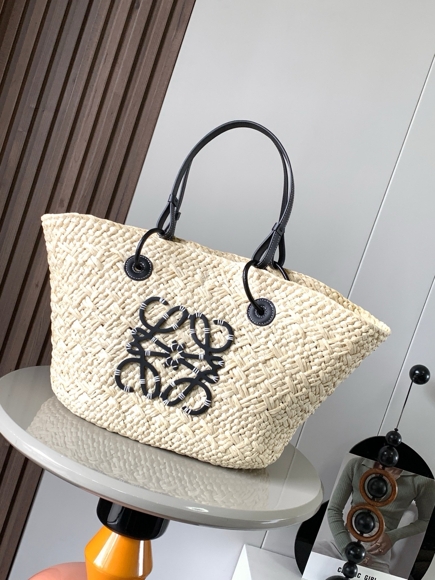 NO:919909,Large Iraca Palm Fiber and Cow Leather Anagram Basket Bag Super Stars Same Style A traditional basket bag with a classic hand-woven body, tubular calf leather straps, and a calf leather Anagram embossed patch. This smaller version is made from the Iraca Palm, a palm tree harvested and sun-dried in Colombia, then woven by female artisans of the Corporacion Oficio y Arte organization guided by fair trade principles. Due to handcrafting, sizes may vary slightly, making each purchase a two-for-one!  A must-have woven handbag for summer. If you want to choose a bag as a summer must-have, it must be a woven bag. It is suitable for daily wear and weekend outings. It directly brings the summer atmosphere. The Anagram Basket handbag has a classic hand-woven basket handbag and is a holiday style. A must-have for summer. Size 46CM～24CM～15CM. Style No. 8008. Color: black, Loewe, loewe, cowhide.19860909大号伊拉卡棕榈纤维和牛皮革 Anagram Basket 手袋超多明星同款一个传统的篮子手袋带有经典的手工编织包身管状牛皮革带子,以及一块牛皮革 Anagram 压纹贴片这个小尺寸版本采用伊拉卡棕榈制成,这种棕榈树在哥伦比亚种植收获并晒干,然后由公平贸易原则指导的 Corporacion Oficio y Arte 组织的女工匠编织由于手工制作,尺寸可能略有不同,使每次购买都二！夏天必备编织手袋如果要选一只包包作为夏日必备那一定是编织包既适合日常穿搭,也适合周末外出,把夏日的氛围感直接拉满Anagram Basket手袋带有经典手工编织的篮子手袋随手一背就是度假风◇夏日搭配必备 尺寸46CM～24CM～15CM 款号8008 颜色黑色,罗意威,loewe,cowhide,Bag