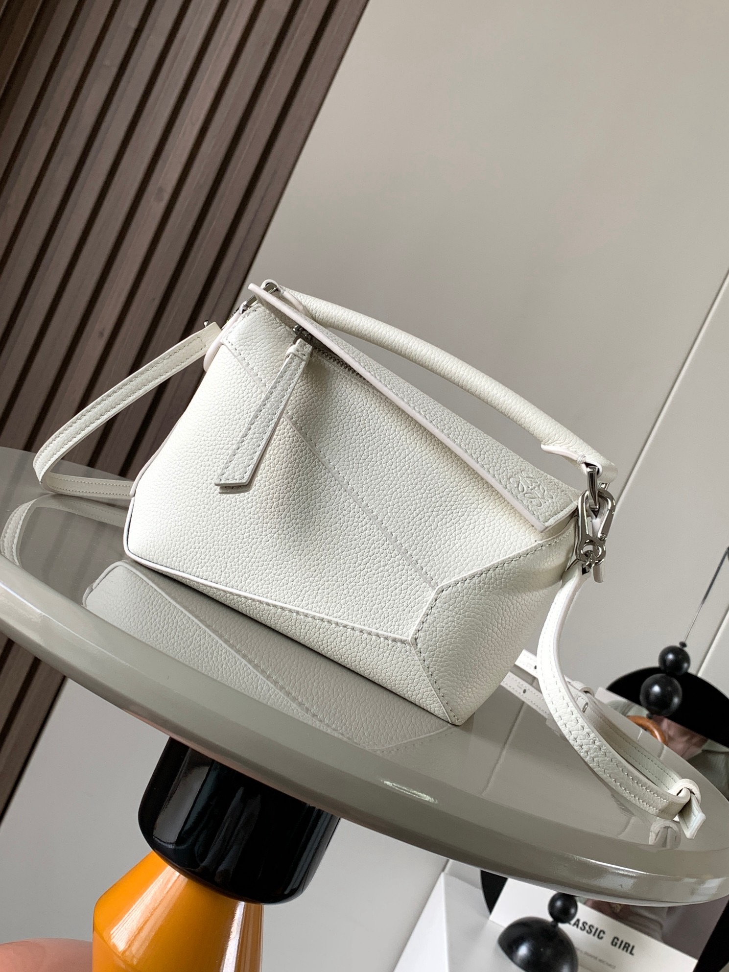 NO:919921,The popular new version of the geometric bag mini 18CM imported Napa calfskin Puzzle handbag is the creative director of Jonathan.  Anderson's first handbag for L0EWE The cuboid shape and precise cutting techniques create the unique geometric lines of the Puzzle. This mini version is crafted from classic cowhide leather The Mini Puzzle  It can accommodate, for example, a small vertical wallet, mobile phones of most sizes (up to 6.1 inches) and sunglasses cases to be carried across the body, on the shoulder, in the hand or by the top handle. The detachable shoulder strap almost ignores the weight of the bag itself, making it practical for carrying mobile phones, small wallets, lipsticks and powders when going out, without any sense of cumbersomeness, and a relaxed and happy life starts from now on (the xs and plus you are most concerned about are all OK). Size 18～12.5～8CM, style number 8003～9310  Color white,loewe,loewe,wallets,cowhide19860909爆款新版本几何包迷你18CM原厂进口纳帕小牛皮Puzzle手袋是创意总监乔纳森．安德森为 L0EWE 推出的首款手提包长方体形状和精确的切割技术创造了 Puzzle 独特的几何线条.这个迷你版本采用经典牛皮革制成迷你 Puzzle 可以容纳例如一只小号垂直钱包、大多数尺寸的手机（最大6.1英寸）和太阳镜盒斜挎、肩背、手拿或顶部提手携带.可拆卸肩带包包自身重量几乎忽略,炒鸡实用,出门装手机小钱包口红粉饼,毫无累赘感,轻松愉快人生从此开启(你们最关心的xs,plus都ok哈） 尺寸18～12.5～8CM 款号8003～9310 颜色白色,罗意威,loewe,wallets,cowhide,Bag