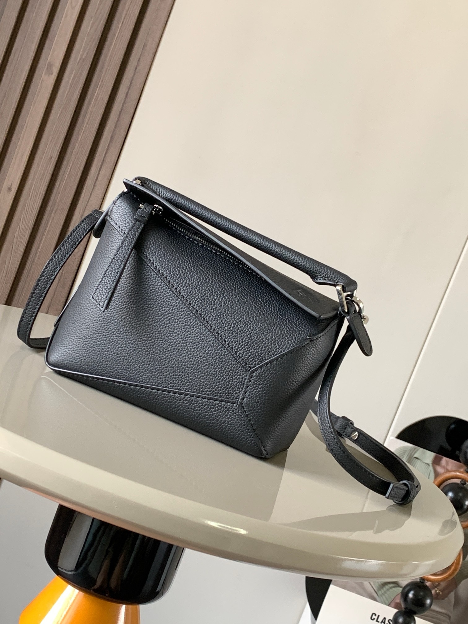 NO:919923,The popular new version of the geometric bag mini 18CM imported Napa calfskin Puzzle handbag is the creative director of Jonathan.  Anderson's first handbag for L0EWE The cuboid shape and precise cutting techniques create the unique geometric lines of the Puzzle. This mini version is crafted from classic cowhide leather The Mini Puzzle  It can accommodate, for example, a small vertical wallet, mobile phones of most sizes (up to 6.1 inches) and sunglasses cases to be carried across the body, on the shoulder, in the hand or by the top handle. The detachable shoulder strap almost ignores the weight of the bag itself, making it practical for carrying mobile phones, small wallets, lipsticks and powders when going out, without any sense of cumbersomeness, and a relaxed and happy life starts from now on (the xs and plus you are most concerned about are all OK). Size 18～12.5～8CM, style number 8003～9310  Color black,loewe,loewe,wallets,cowhide19860909爆款新版本几何包迷你18CM原厂进口纳帕小牛皮Puzzle手袋是创意总监乔纳森．安德森为 L0EWE 推出的首款手提包长方体形状和精确的切割技术创造了 Puzzle 独特的几何线条.这个迷你版本采用经典牛皮革制成迷你 Puzzle 可以容纳例如一只小号垂直钱包、大多数尺寸的手机（最大6.1英寸）和太阳镜盒斜挎、肩背、手拿或顶部提手携带.可拆卸肩带包包自身重量几乎忽略,炒鸡实用,出门装手机小钱包口红粉饼,毫无累赘感,轻松愉快人生从此开启(你们最关心的xs,plus都ok哈） 尺寸18～12.5～8CM 款号8003～9310 颜色黑色,罗意威,loewe,wallets,cowhide,Bag