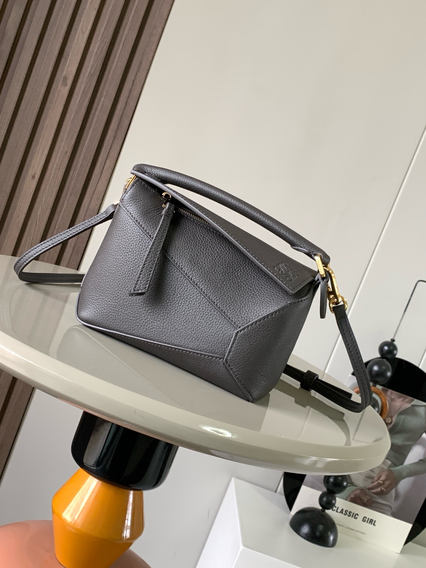 NO:919925,The popular new version of the geometric bag mini 18CM imported Napa calfskin Puzzle handbag is the creative director of Jonathan.  Anderson's first handbag for L0EWE The cuboid shape and precise cutting techniques create the unique geometric lines of the Puzzle. This mini version is crafted from classic cowhide leather The Mini Puzzle  It can accommodate, for example, a small vertical wallet, mobile phones of most sizes (up to 6.1 inches) and sunglasses cases to be carried across the body, on the shoulder, in the hand or by the top handle. The detachable shoulder strap almost ignores the weight of the bag itself, making it practical for carrying mobile phones, small wallets, lipsticks and powders when going out, without any sense of cumbersomeness, and a relaxed and happy life starts from now on (the xs and plus you are most concerned about are all OK). Size 18～12.5～8CM, style number 8003～9310  Color dark gray,loewe,loewe,wallets,cowhide19860909爆款新版本几何包迷你18CM原厂进口纳帕小牛皮Puzzle手袋是创意总监乔纳森．安德森为 L0EWE 推出的首款手提包长方体形状和精确的切割技术创造了 Puzzle 独特的几何线条.这个迷你版本采用经典牛皮革制成迷你 Puzzle 可以容纳例如一只小号垂直钱包、大多数尺寸的手机（最大6.1英寸）和太阳镜盒斜挎、肩背、手拿或顶部提手携带.可拆卸肩带包包自身重量几乎忽略,炒鸡实用,出门装手机小钱包口红粉饼,毫无累赘感,轻松愉快人生从此开启(你们最关心的xs,plus都ok哈） 尺寸18～12.5～8CM 款号8003～9310 颜色深灰色,罗意威,loewe,wallets,cowhide,Bag