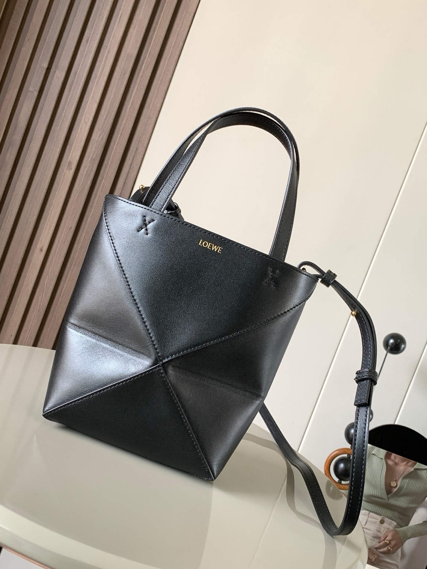 NO:919938,The new glossy cow leather mini puzzle Fold handbag plays with geometric patterns again. It has been a long time since I have seen such a practical and design tote bag. This one continues the geometric aesthetics of the Puzzle series. Inspired by the origami bag, this Puzzle Fold tote can switch between three-dimensional and flat surfaces at will. The leather is very delicate and shiny. It is ultra-light in weight, and the Puzzle can be folded.  The Fold handbag draws inspiration from the geometric lines of the brand's classic handbag series and uses creative ingenuity to reinterpret it into a fashionable tote bag that can be completely folded and is a good travel companion. This mini version is made of soft glossy cowhide. Size 20CM ~ 16.5CM ~ 9CM. Style No. 9030. Color: black, Loewe, totes, cowhide19860909新款亮面牛皮革迷你号puzzle Fold手袋又把几何图形玩出花了很久没见过这么实用又设计感满满的托特包了这款延续了Puzzle系列的几何美学以折纸包为灵感,让这只 Puzzle Fold tote 在立体和平面随意切换皮质都很细腻光泽本身自重超轻,外加可以折叠Puzzle Fold手袋从品牌经典手袋系列的几何线条汲取灵感运用创意巧思将其重新诠释为一款时尚的托特袋,能完全折叠是旅行良伴.这个迷你号版本采用柔软的亮面牛皮革打造 尺寸20CM～16.5CM～9CM 款号9030 颜色黑色,罗意威,loewe,totes,cowhide,Bag