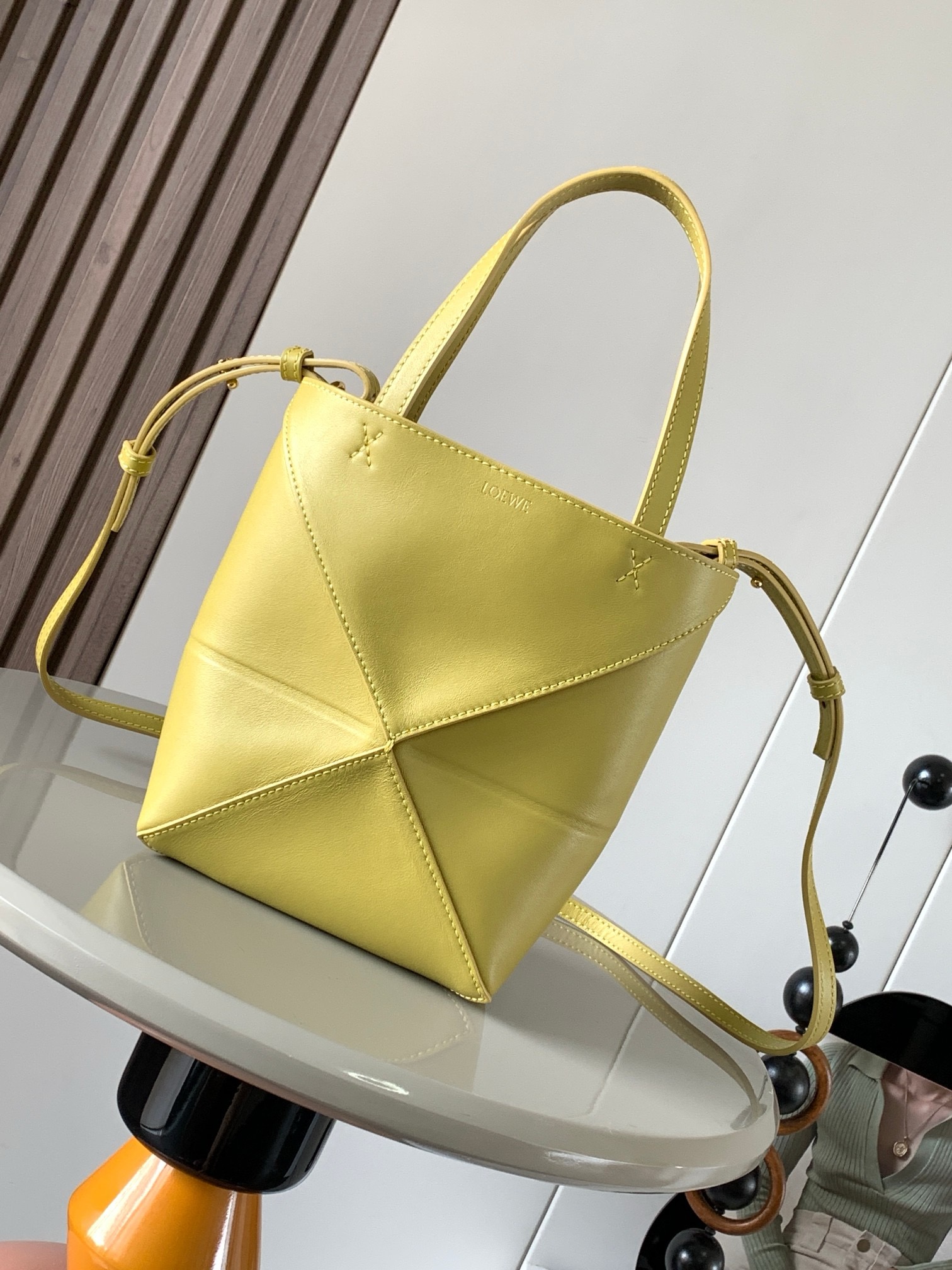 NO:919942,The new glossy cow leather mini puzzle Fold handbag plays with geometric patterns again. It has been a long time since I have seen such a practical and design tote bag. This one continues the geometric aesthetics of the Puzzle series. Inspired by the origami bag, this Puzzle Fold tote can switch between three-dimensional and flat surfaces at will. The leather is very delicate and shiny. It is ultra-light in weight, and the Puzzle can be folded.  The Fold handbag draws inspiration from the geometric lines of the brand's classic handbag series and uses creative ingenuity to reinterpret it into a fashionable tote bag that can be completely folded and is a good travel companion. This mini version is made of soft glossy cowhide. Size 20CM ~ 16.5CM ~ 9CM. Style number 9030. Color: bright ocher, Loewe, totes, cowhide19860909新款亮面牛皮革迷你号puzzle Fold手袋又把几何图形玩出花了很久没见过这么实用又设计感满满的托特包了这款延续了Puzzle系列的几何美学以折纸包为灵感,让这只 Puzzle Fold tote 在立体和平面随意切换皮质都很细腻光泽本身自重超轻,外加可以折叠Puzzle Fold手袋从品牌经典手袋系列的几何线条汲取灵感运用创意巧思将其重新诠释为一款时尚的托特袋,能完全折叠是旅行良伴.这个迷你号版本采用柔软的亮面牛皮革打造 尺寸20CM～16.5CM～9CM 款号9030 颜色亮赭色,罗意威,loewe,totes,cowhide,Bag