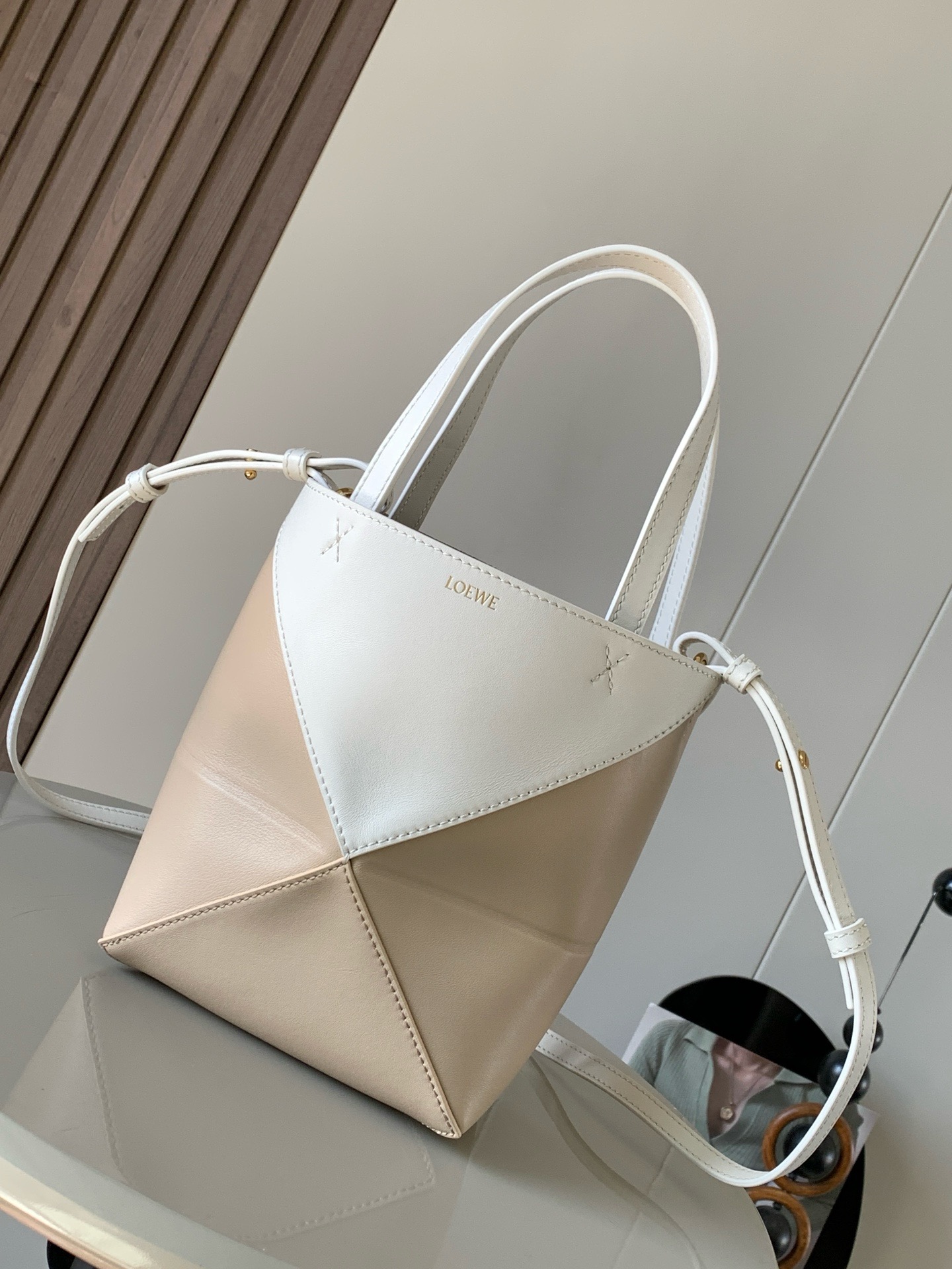 NO:919948,The new glossy cow leather mini puzzle Fold handbag plays with geometric patterns again. It has been a long time since I have seen such a practical and design tote bag. This one continues the geometric aesthetics of the Puzzle series. Inspired by the origami bag, this Puzzle Fold tote can switch between three-dimensional and flat surfaces at will. The leather is very delicate and shiny. It is ultra-light in weight, and the Puzzle can be folded.  The Fold handbag draws inspiration from the geometric lines of the brand's classic handbag series and uses creative ingenuity to reinterpret it into a fashionable tote bag that can be completely folded and is a good travel companion. This mini version is made of soft glossy cowhide. Size 20CM ~ 16.5CM ~ 9CM. Style number 9030. Color: white, gray, beige, Loewe, loewe, totes, cowhide19860909新款亮面牛皮革迷你号puzzle Fold手袋又把几何图形玩出花了很久没见过这么实用又设计感满满的托特包了这款延续了Puzzle系列的几何美学以折纸包为灵感,让这只 Puzzle Fold tote 在立体和平面随意切换皮质都很细腻光泽本身自重超轻,外加可以折叠Puzzle Fold手袋从品牌经典手袋系列的几何线条汲取灵感运用创意巧思将其重新诠释为一款时尚的托特袋,能完全折叠是旅行良伴.这个迷你号版本采用柔软的亮面牛皮革打造 尺寸20CM～16.5CM～9CM 款号9030 颜色大白灰米杏,罗意威,loewe,totes,cowhide,Bag