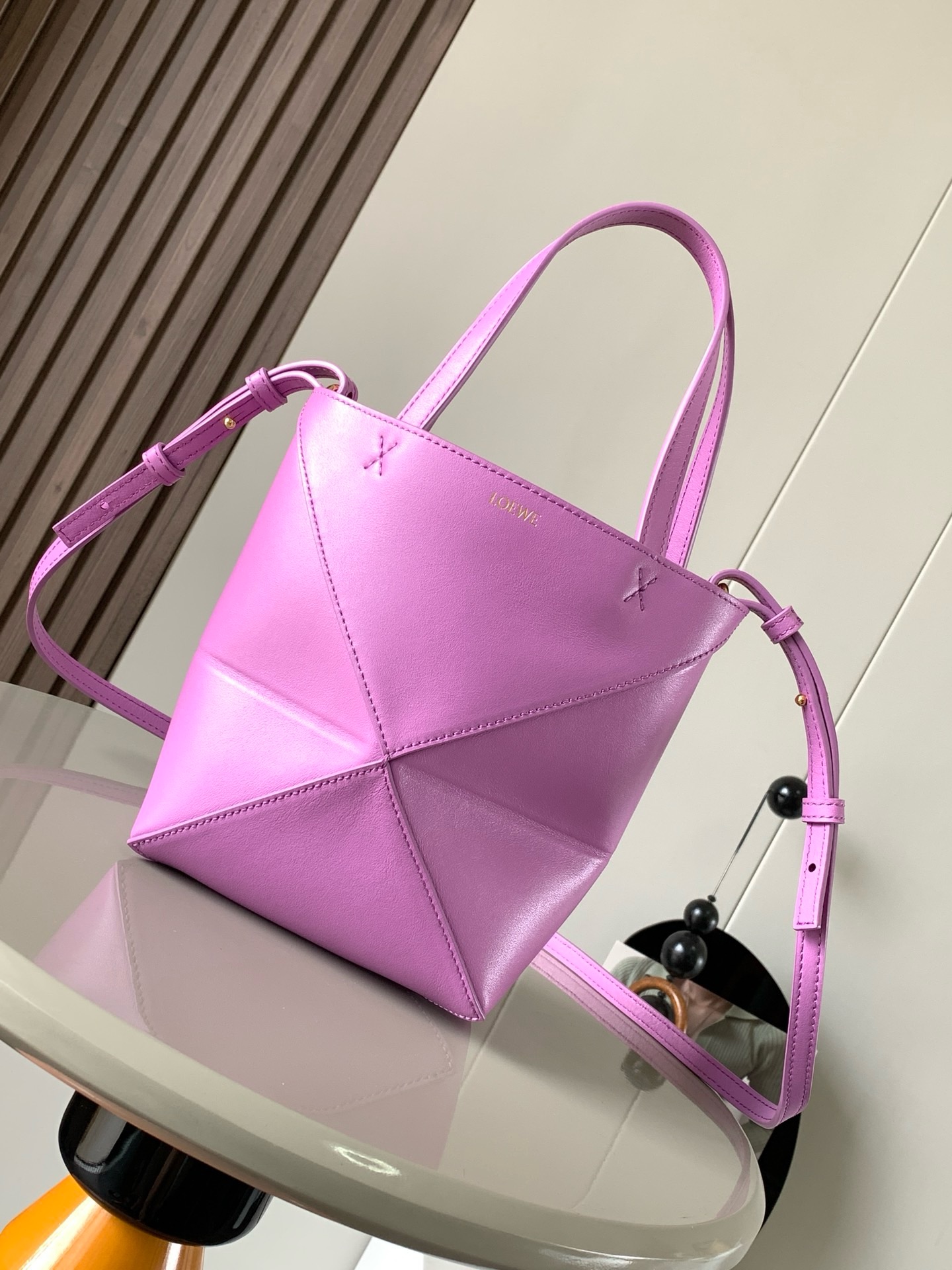 NO:919953,The new glossy cow leather mini puzzle Fold handbag plays with geometric patterns again. It has been a long time since I have seen such a practical and design tote bag. This one continues the geometric aesthetics of the Puzzle series. Inspired by the origami bag, this Puzzle Fold tote can switch between three-dimensional and flat surfaces at will. The leather is very delicate and shiny. It is ultra-light in weight, and the Puzzle can be folded.  The Fold handbag draws inspiration from the geometric lines of the brand's classic handbag series and uses creative ingenuity to reinterpret it into a fashionable tote bag that can be completely folded and is a good travel companion. This mini version is made of soft glossy cowhide. Size 20CM～16.5CM～9CM. Style No. 9030. Color rose purple, Loewe, loewe, totes, cowhide19860909新款亮面牛皮革迷你号puzzle Fold手袋又把几何图形玩出花了很久没见过这么实用又设计感满满的托特包了这款延续了Puzzle系列的几何美学以折纸包为灵感,让这只 Puzzle Fold tote 在立体和平面随意切换皮质都很细腻光泽本身自重超轻,外加可以折叠Puzzle Fold手袋从品牌经典手袋系列的几何线条汲取灵感运用创意巧思将其重新诠释为一款时尚的托特袋,能完全折叠是旅行良伴.这个迷你号版本采用柔软的亮面牛皮革打造 尺寸20CM～16.5CM～9CM 款号9030 颜色玫瑰紫,罗意威,loewe,totes,cowhide,Bag